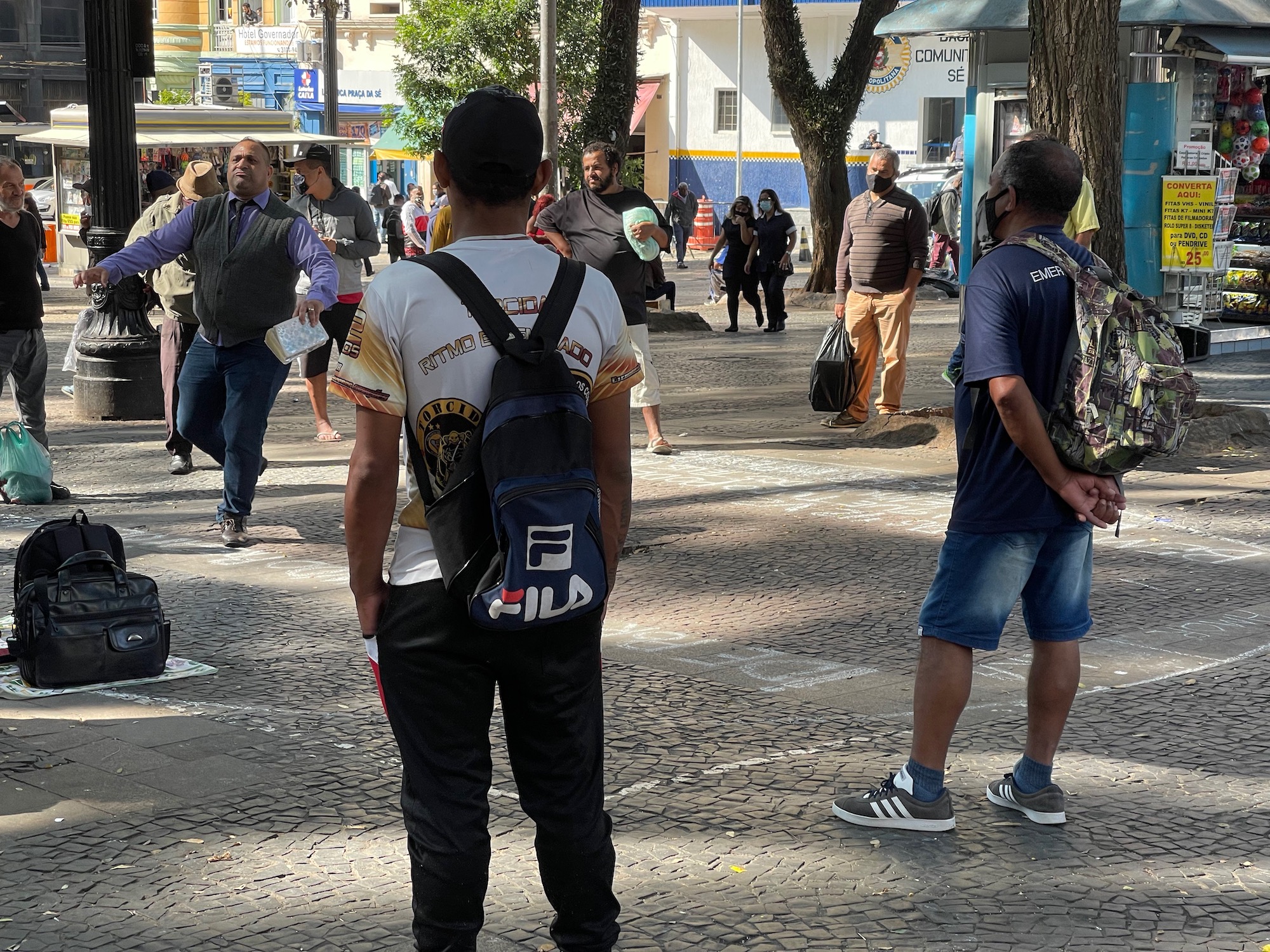 a man with a backpack standing on a sidewalk