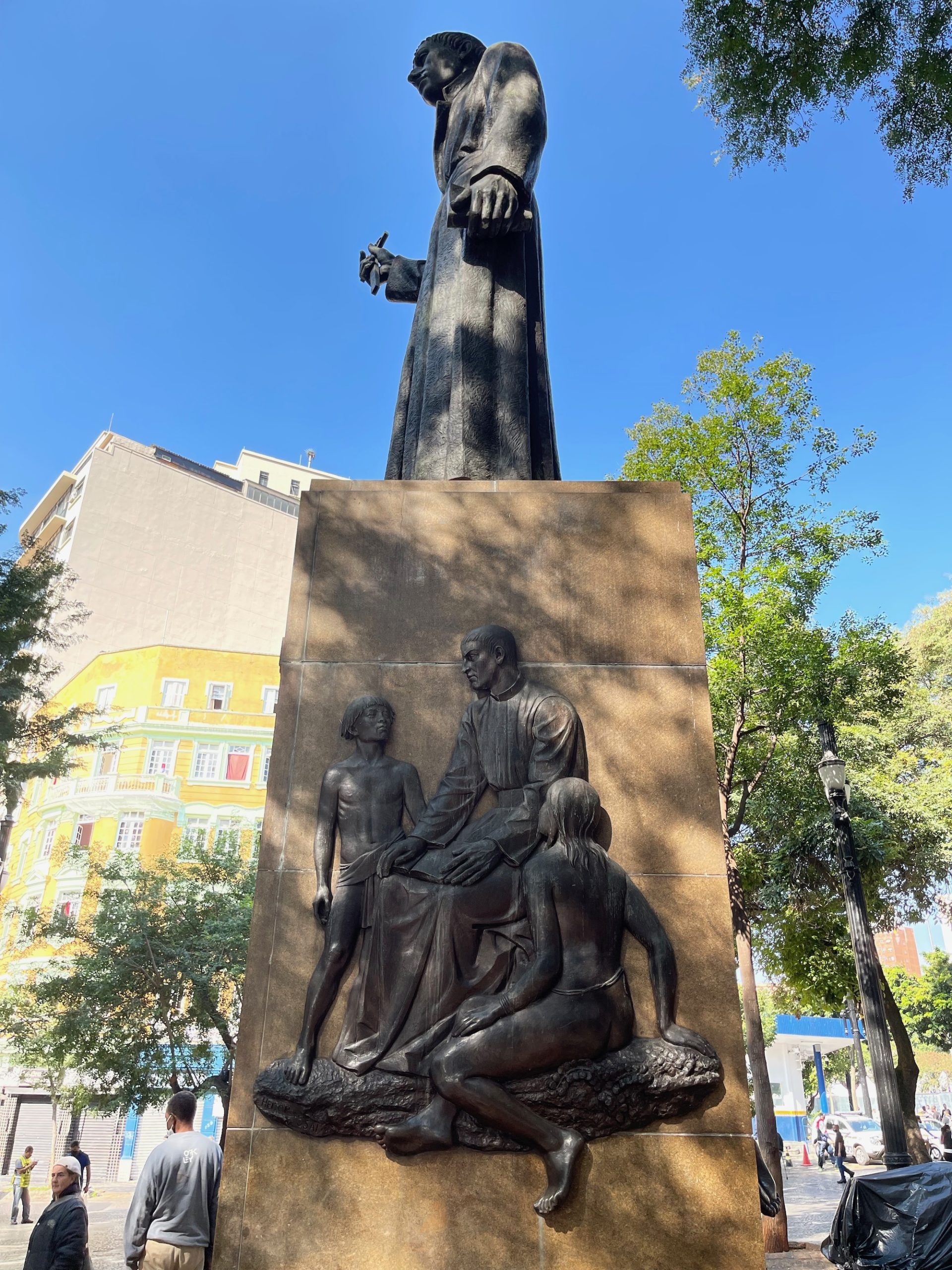 a statue of a man with a long robe and a man holding a hand up