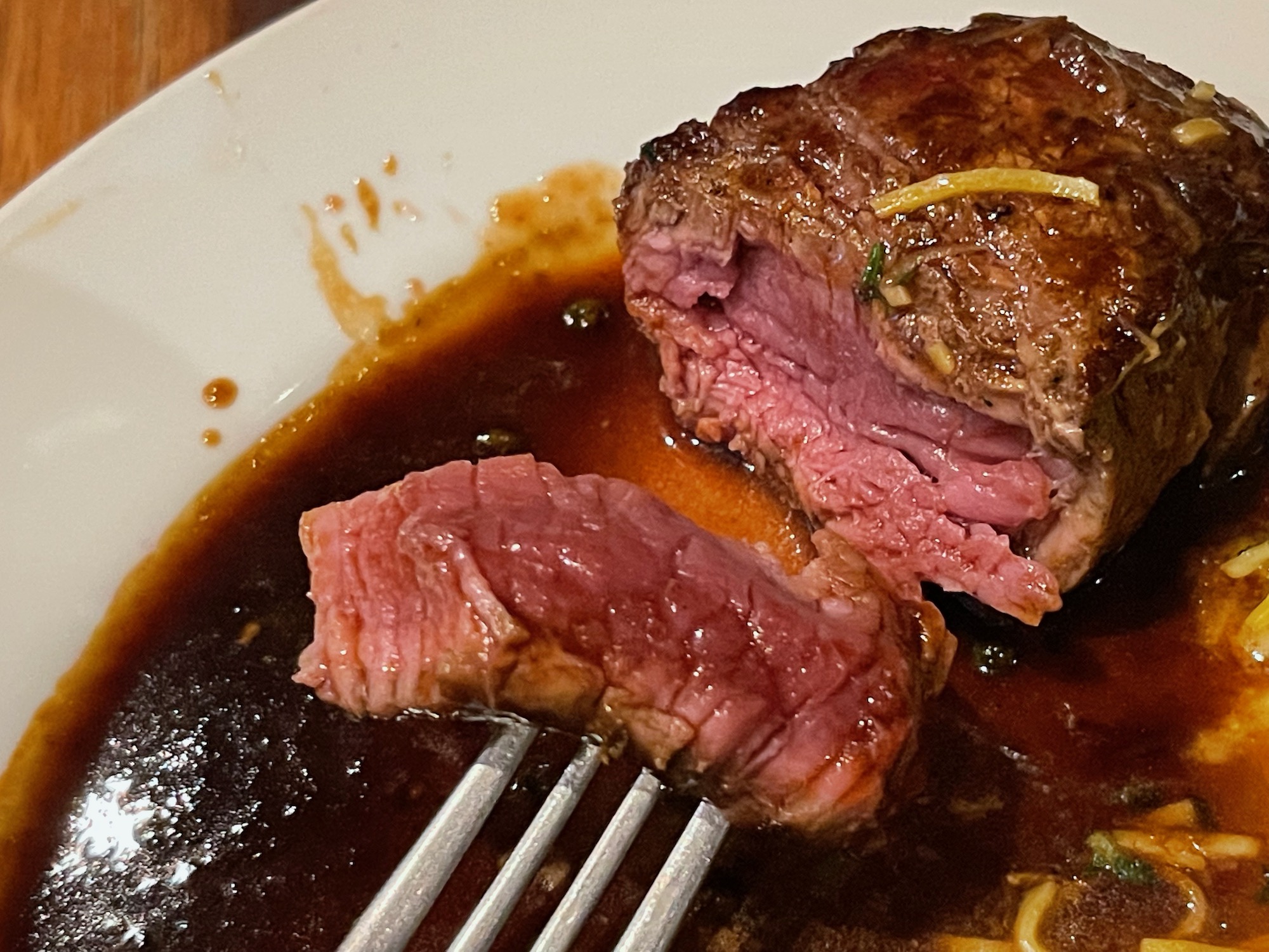 a piece of steak on a plate with sauce