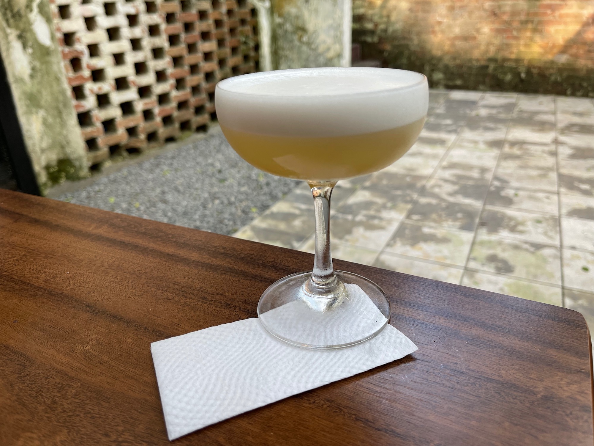 a glass of yellow liquid on a wood surface