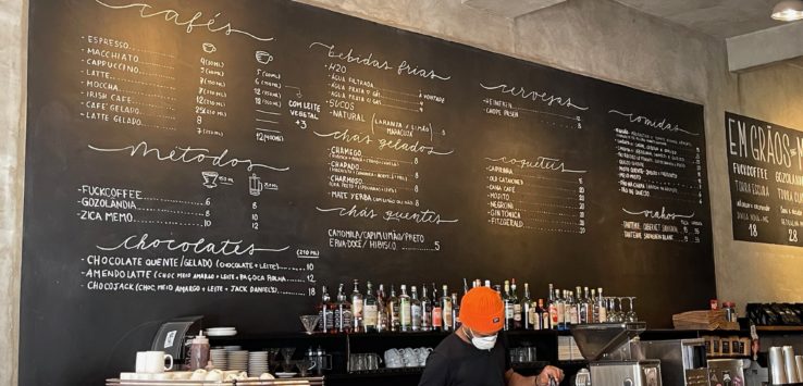 a person in a black shirt behind a blackboard with white writing