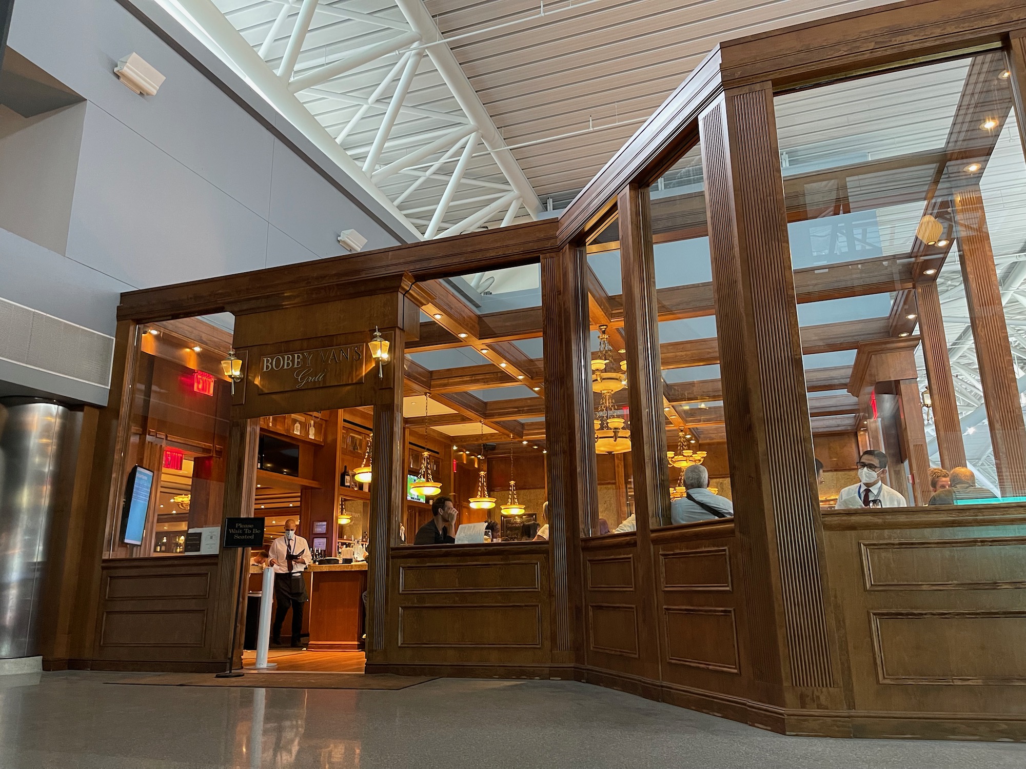 a large glass wall with people standing around it