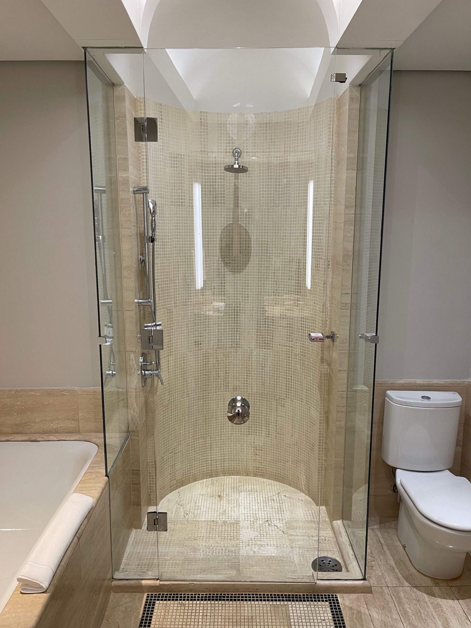a shower with glass doors and a bathtub