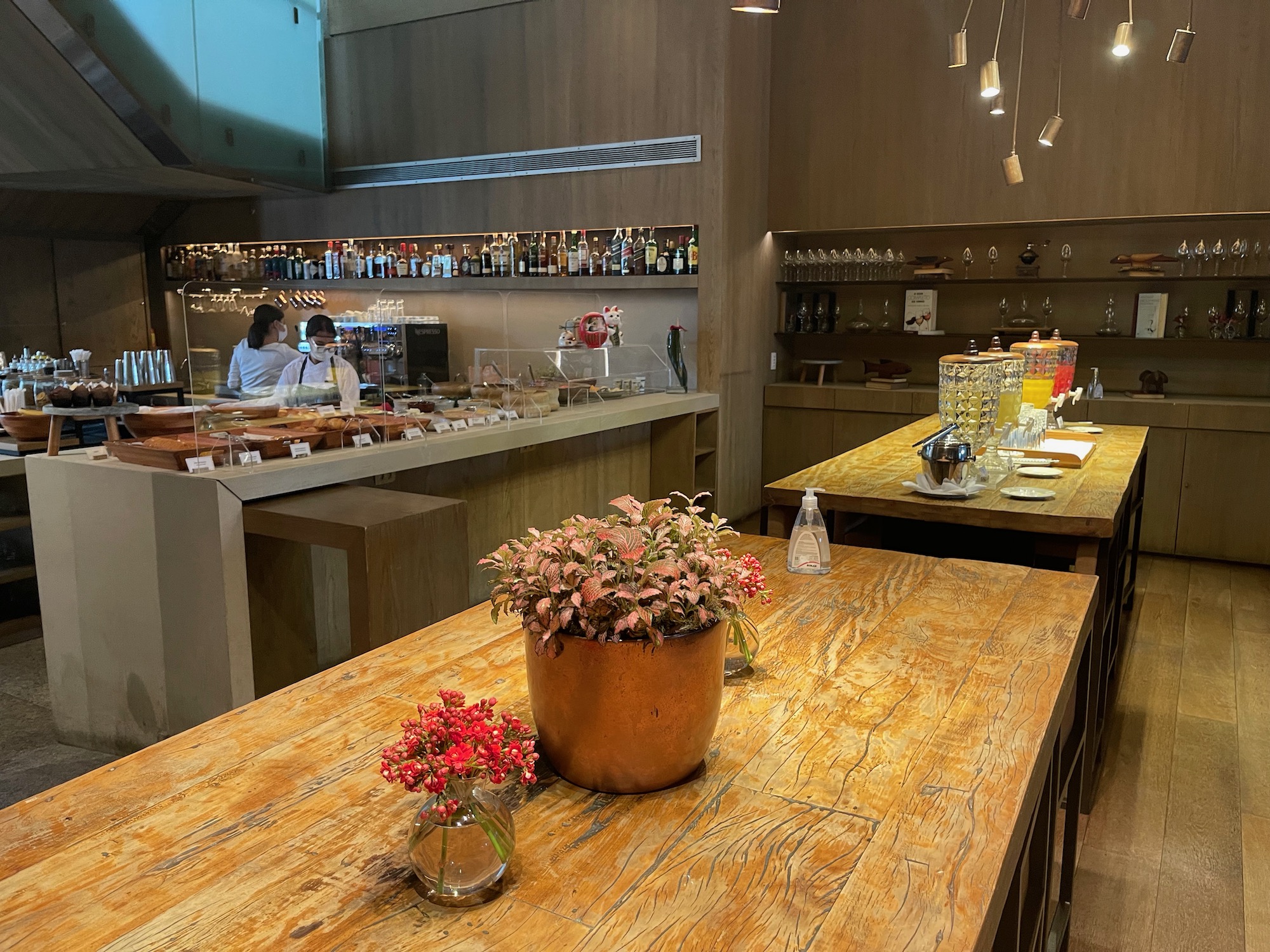 a restaurant with a flower pot on a wooden table