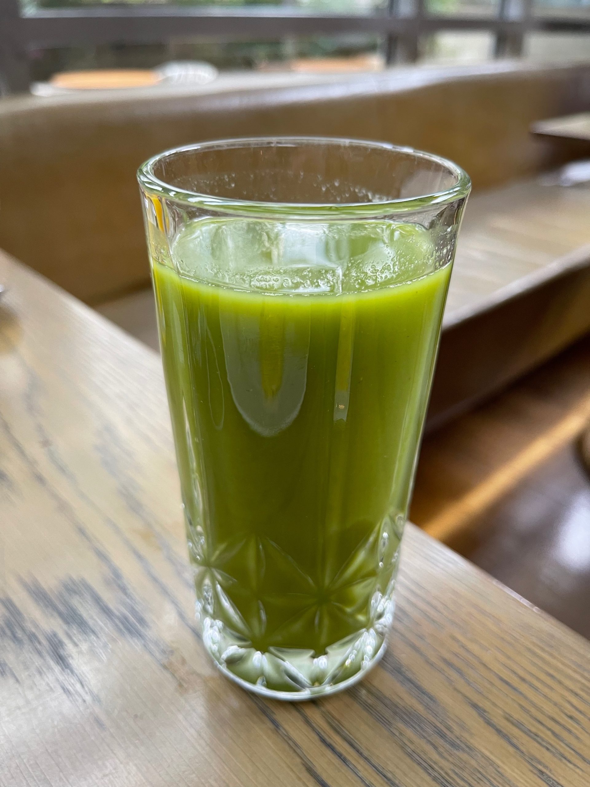 a glass of green liquid on a table