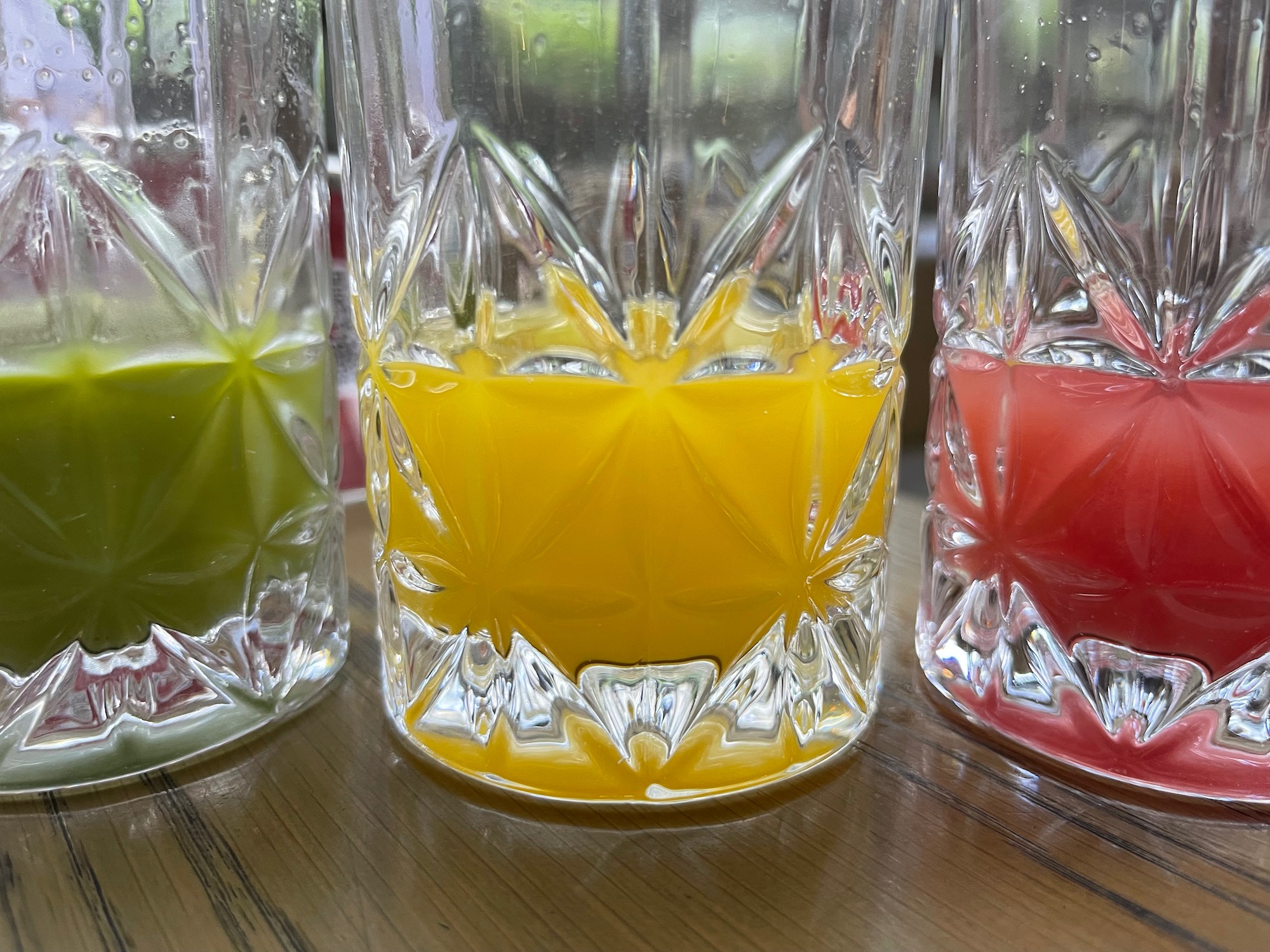 a group of glasses with different colored liquid in them