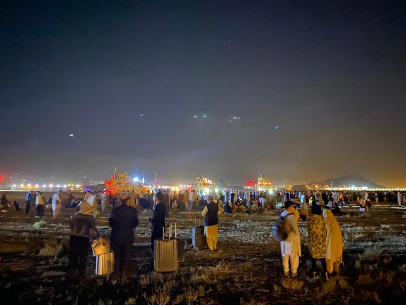 a group of people standing in a field at night