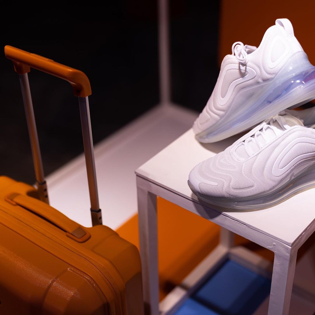 a pair of white sneakers and a suitcase