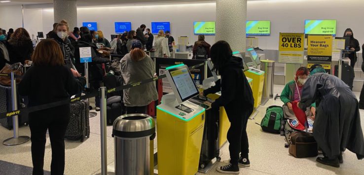 a group of people at an airport check in counters