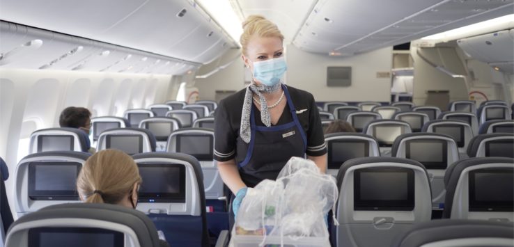 a woman wearing a mask and gloves in an airplane