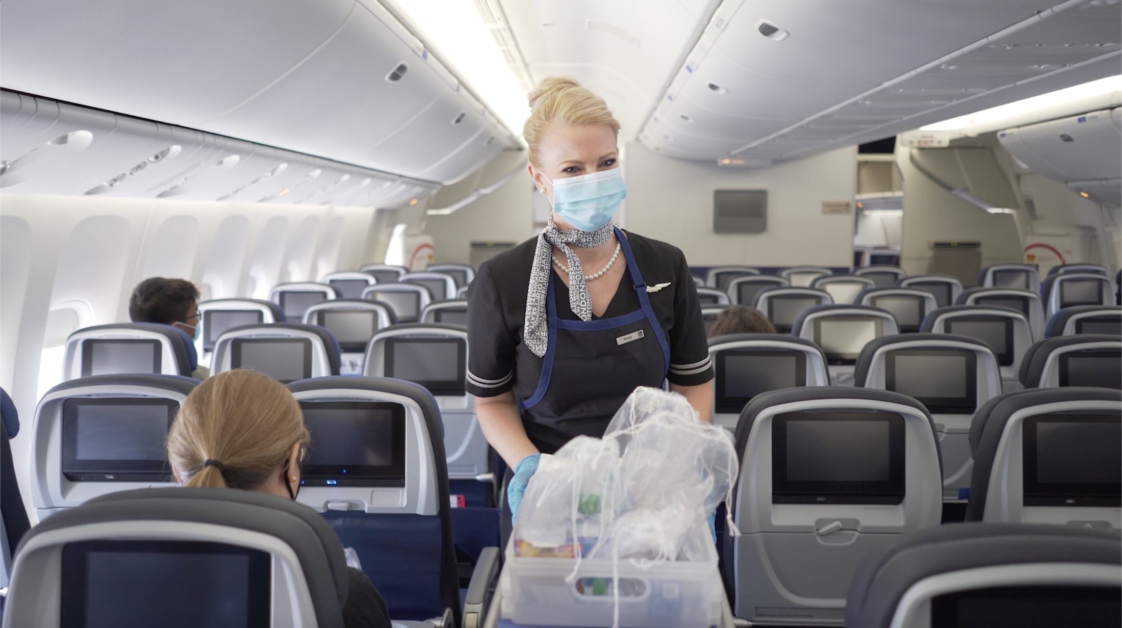 a woman wearing a mask and gloves in an airplane