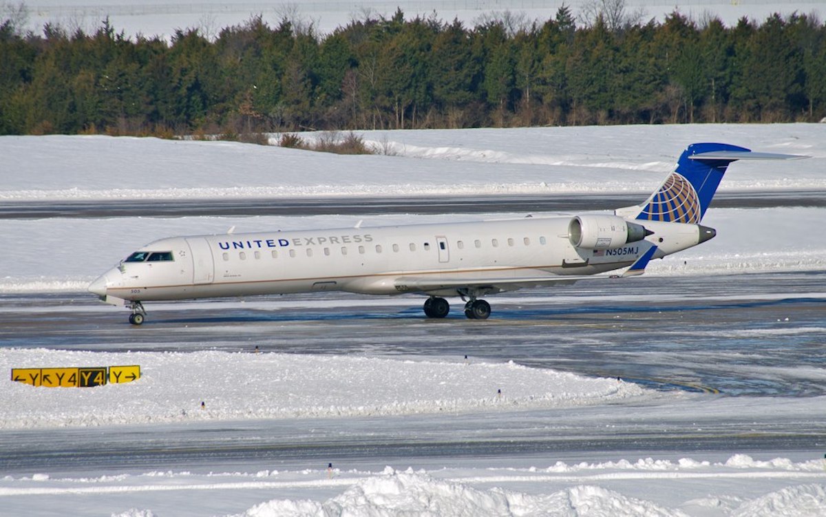 a plane on a runway in the snow