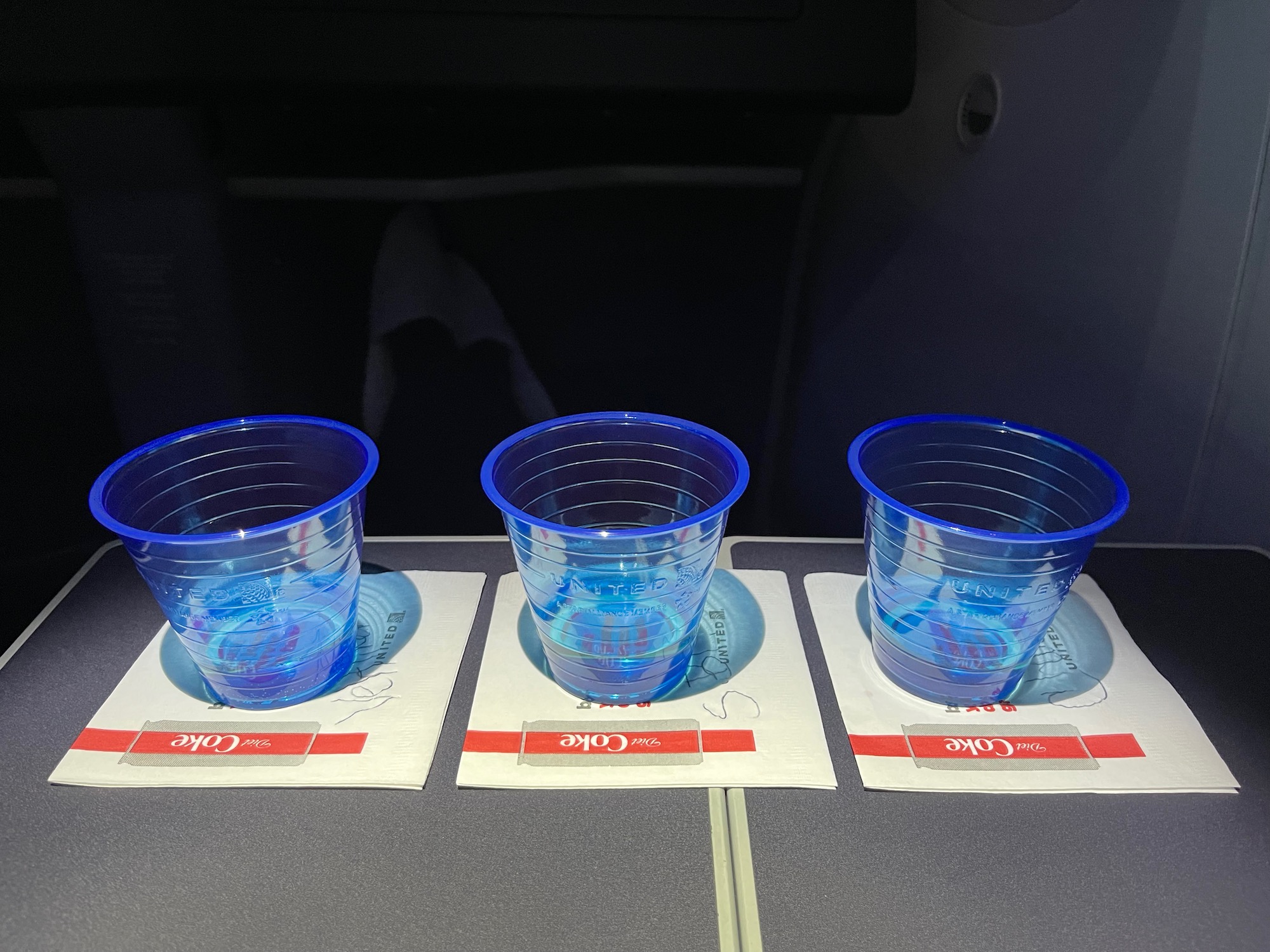 a group of blue plastic cups on coasters