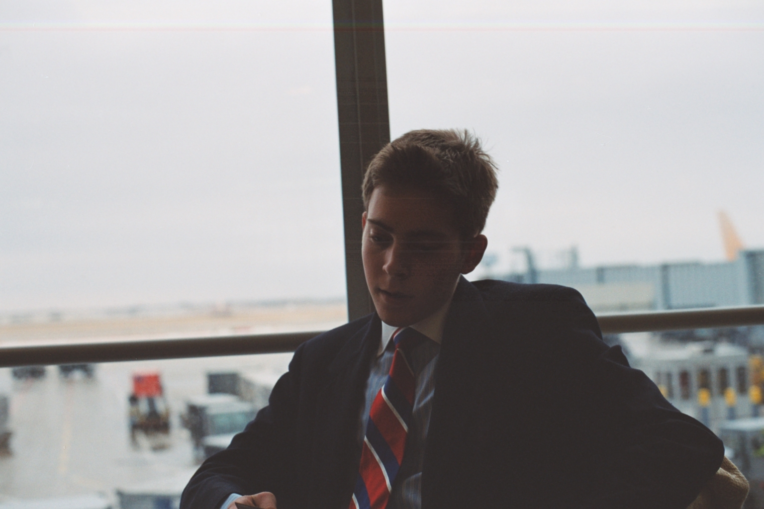 a man in a suit and tie looking at his phone