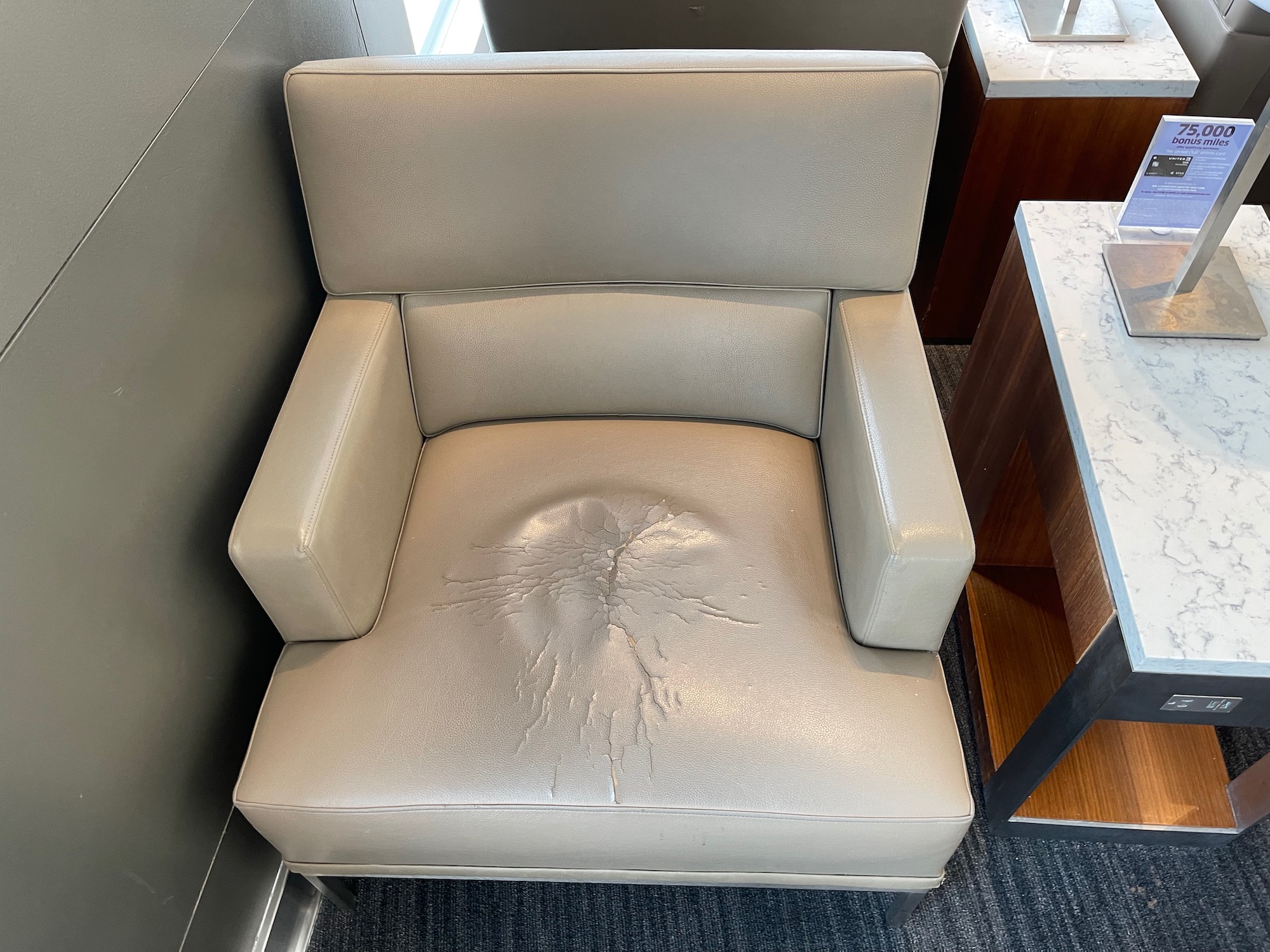 a white leather chair with a stain on the seat