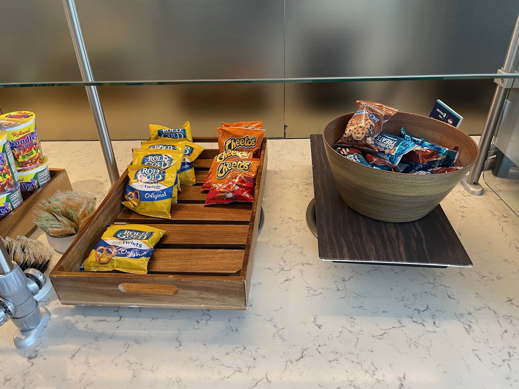 a bowl of snacks and a wooden tray on a table