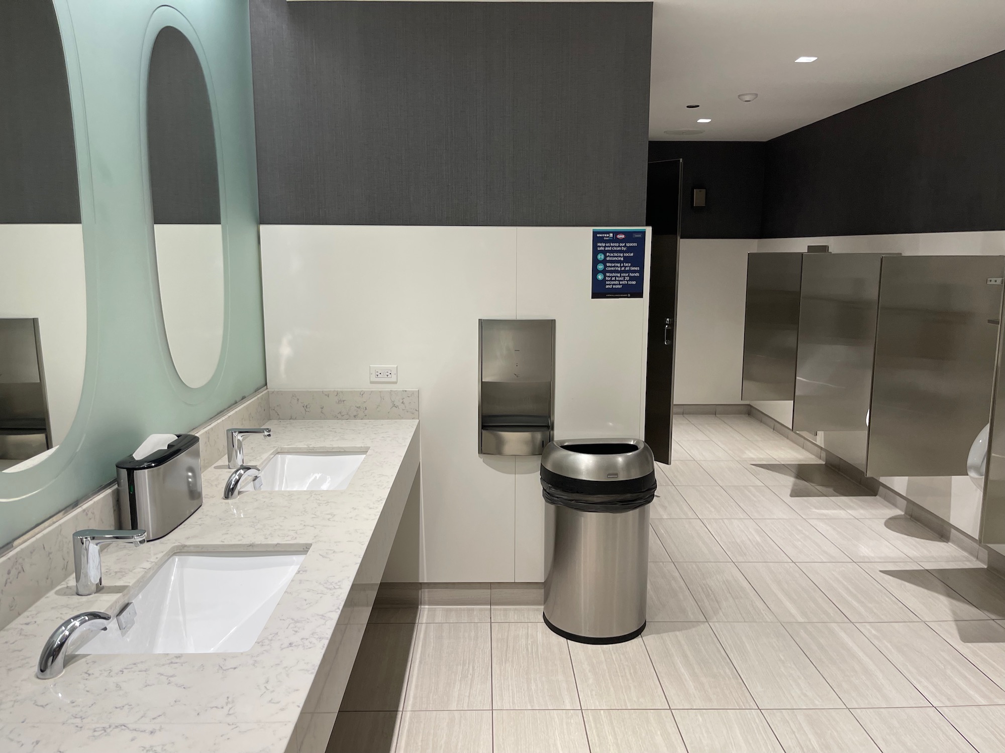 a bathroom with sinks and a trash can