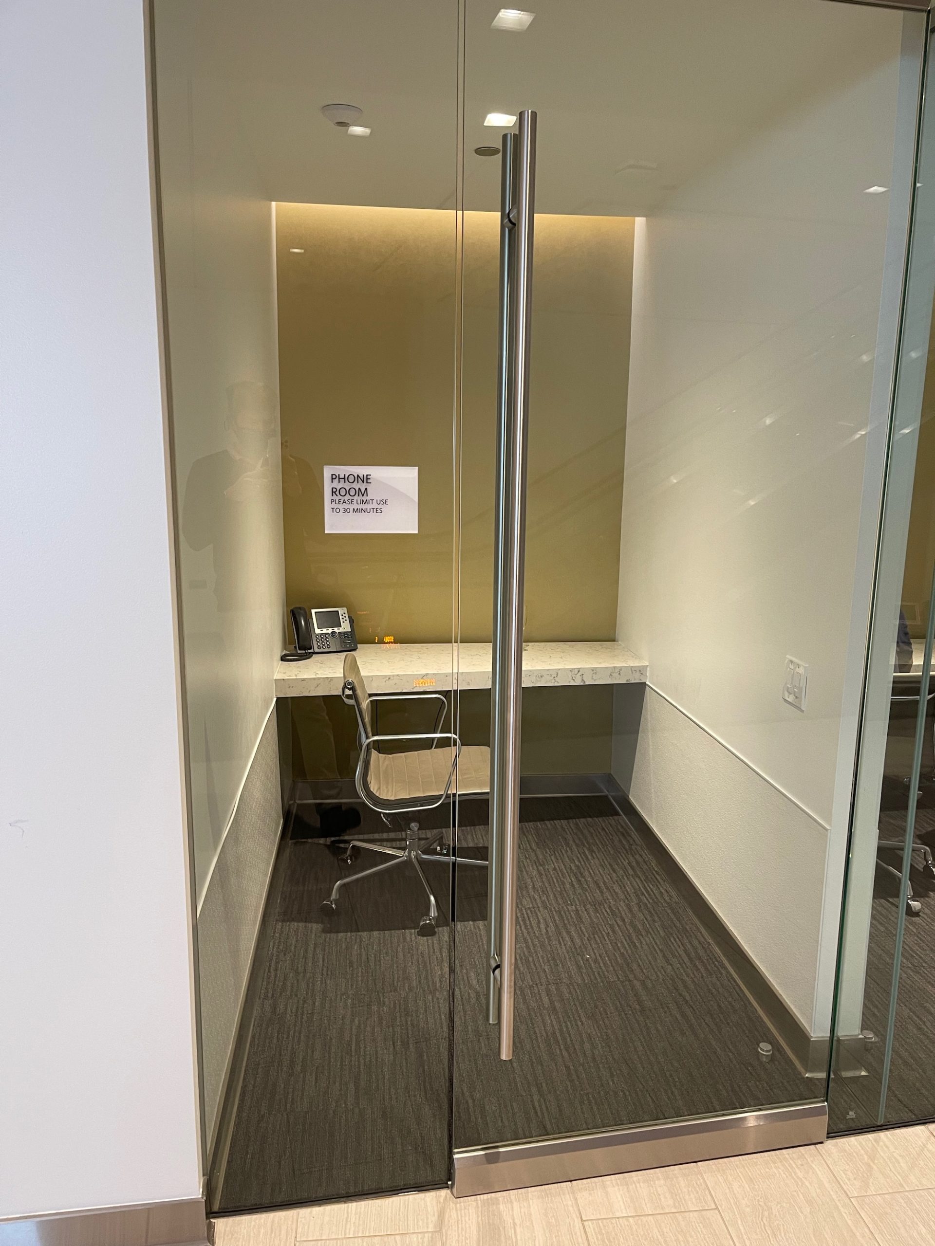 a glass door with a desk and chair