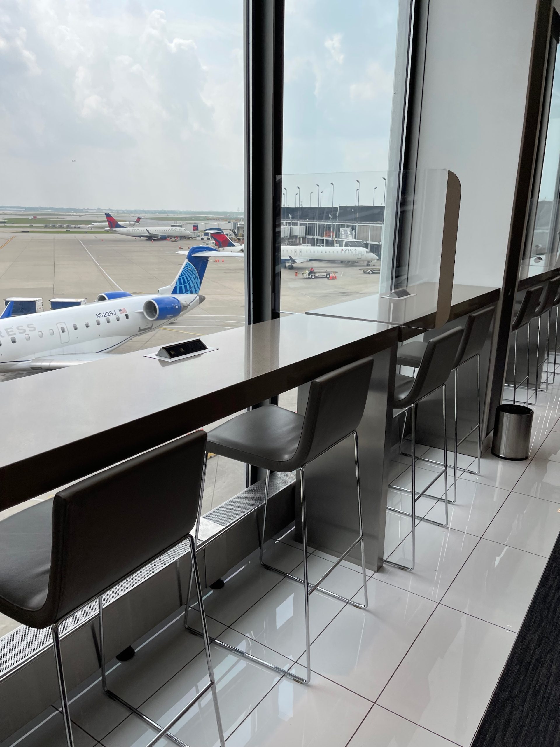 a table with chairs and a window with planes in the background