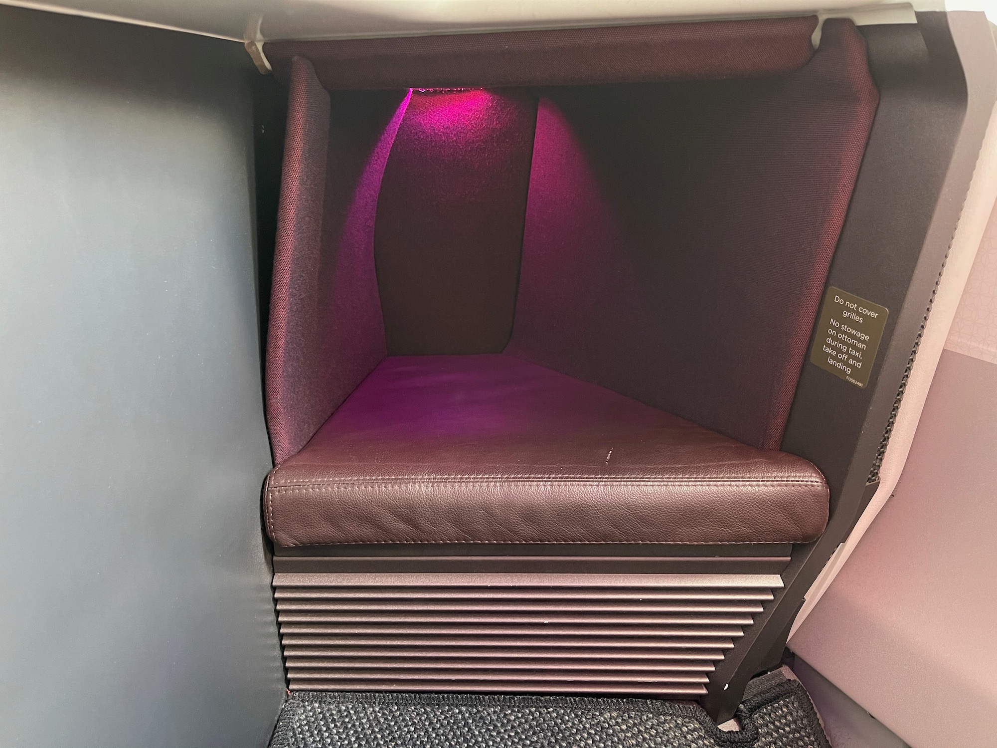 a purple cushioned chair in a room