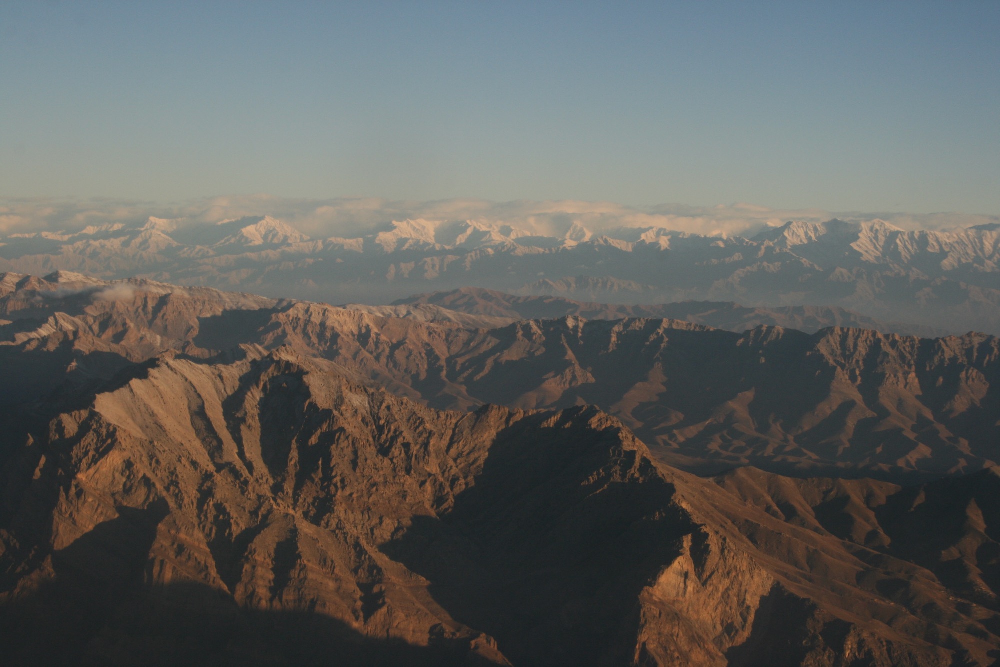 a mountain range with snow capped mountains in the background