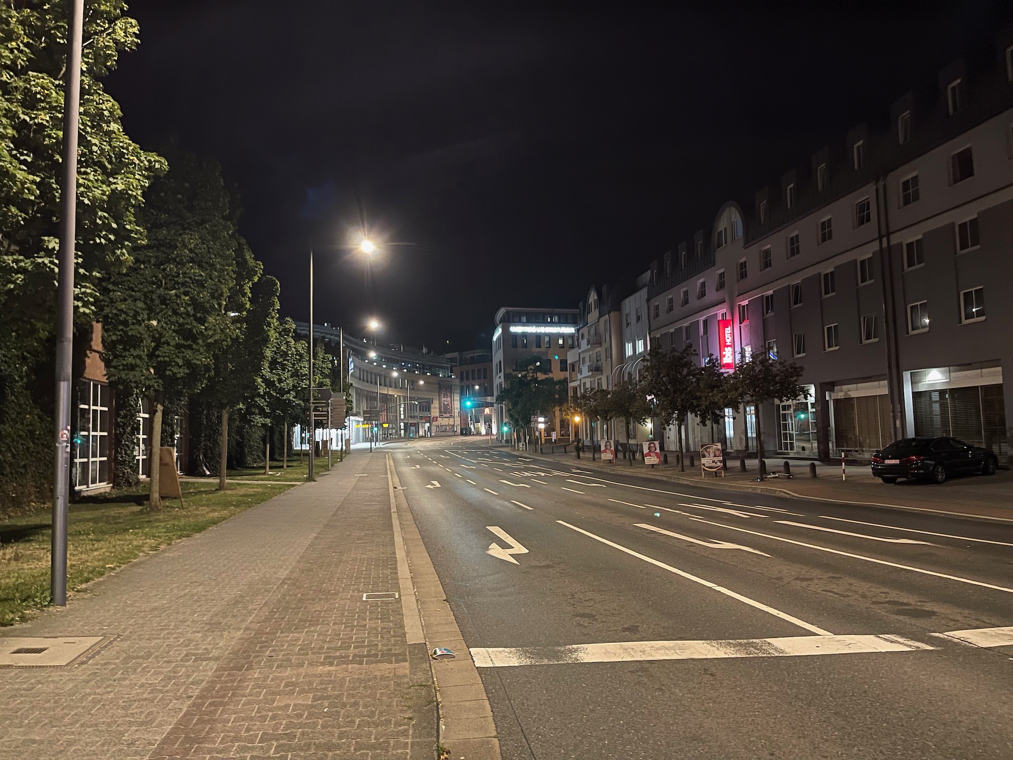 a street with trees and buildings at night