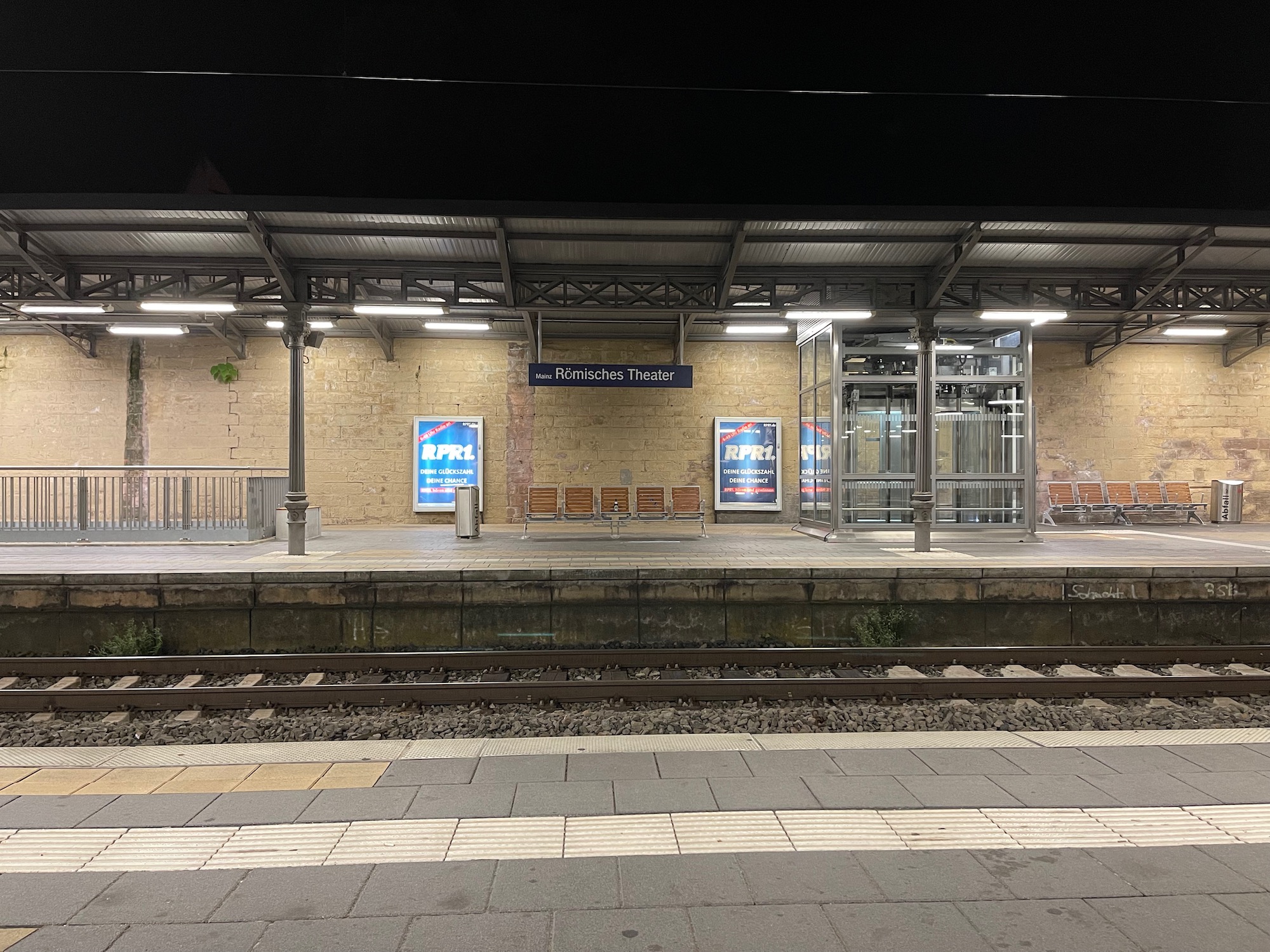 a train station with a platform and benches