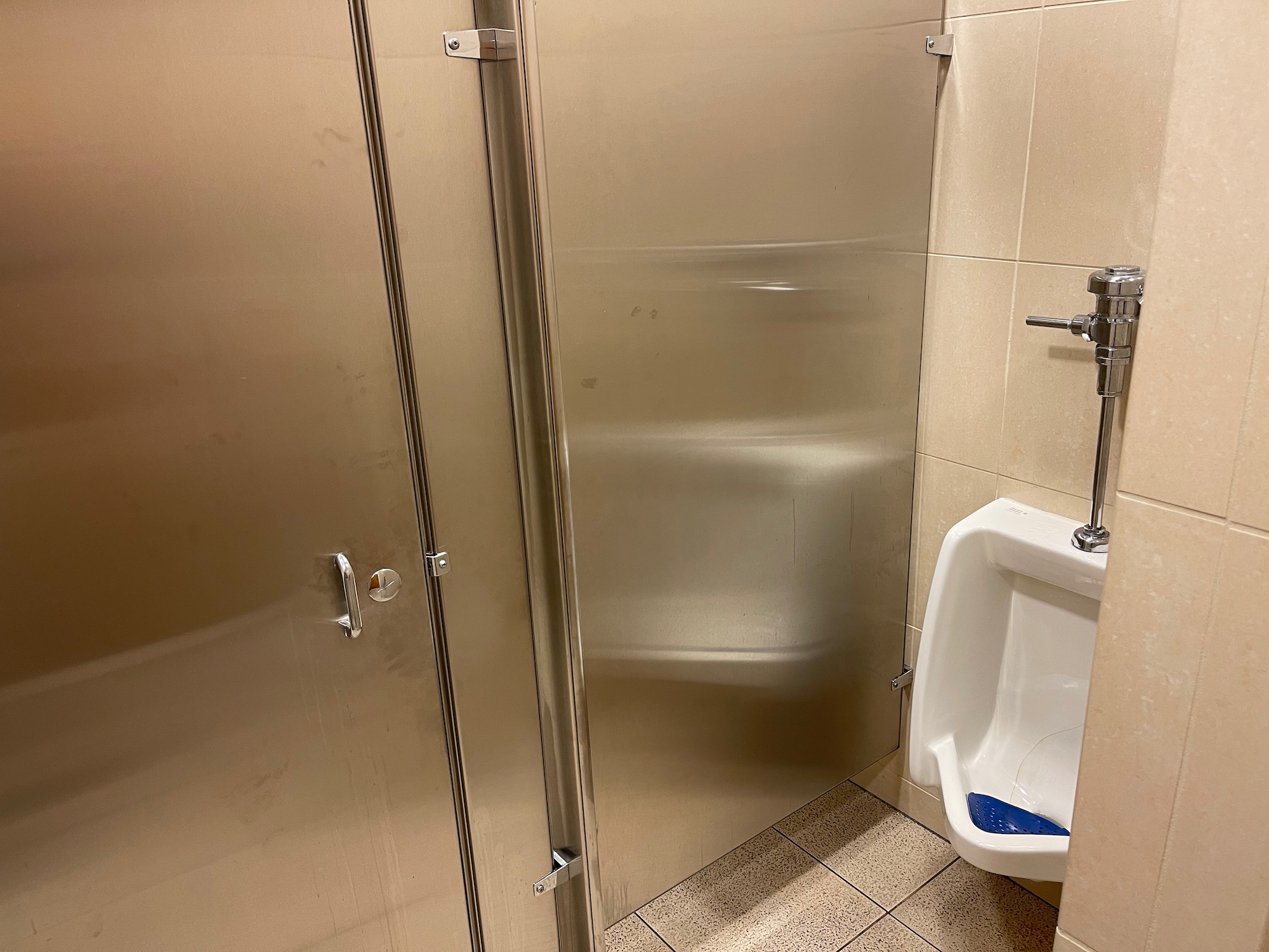 a bathroom with a urinal and a urinal