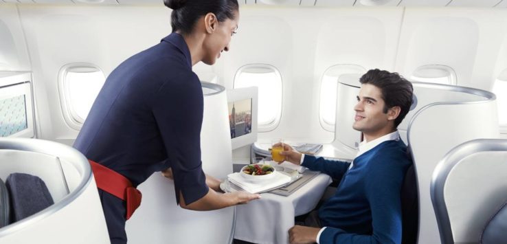a woman serving a man in an airplane