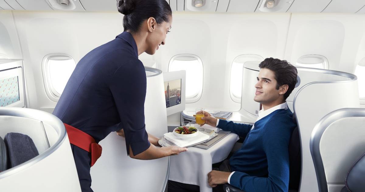 a woman serving a man in an airplane
