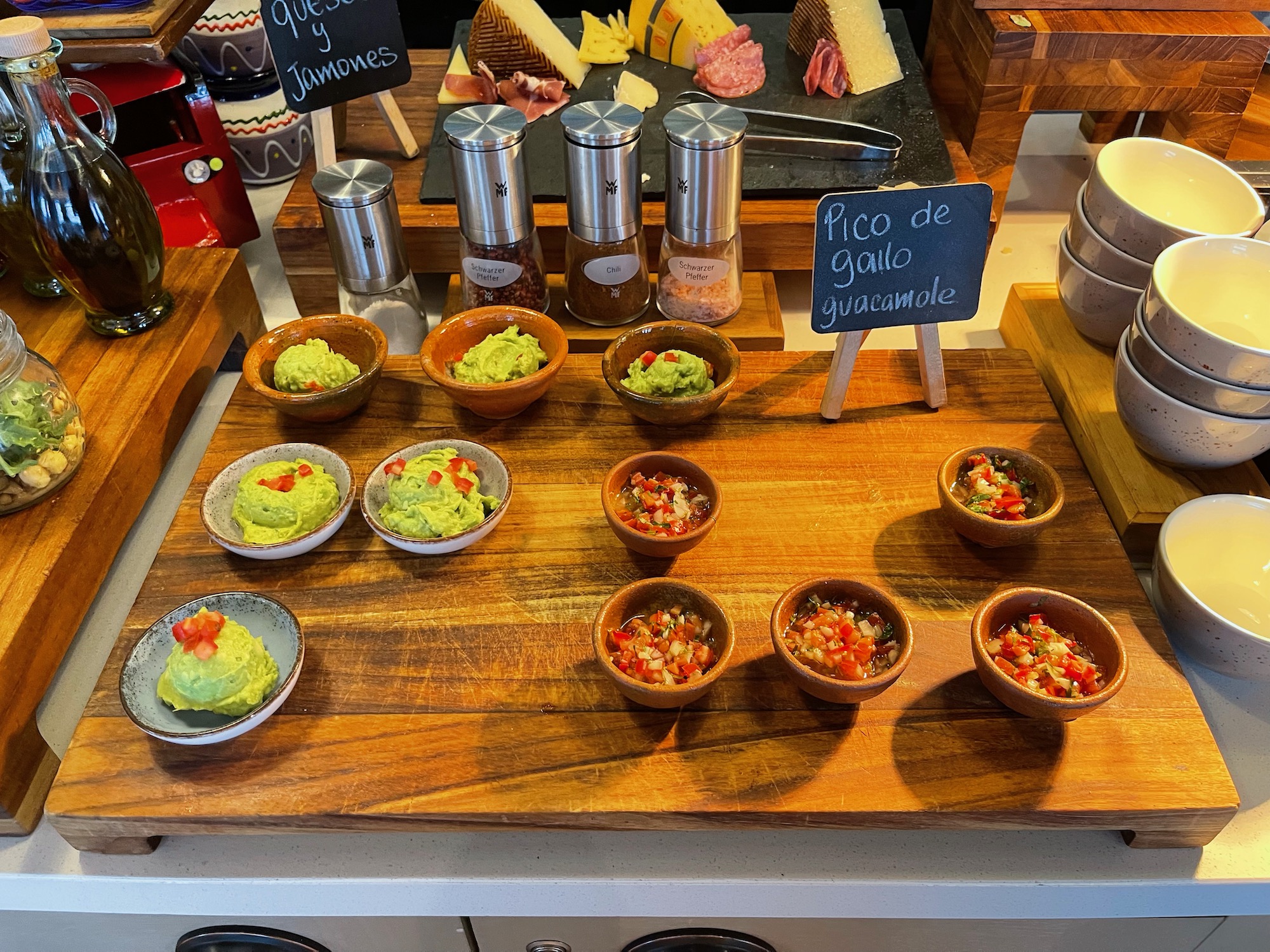a table with bowls of guacamole and other food items