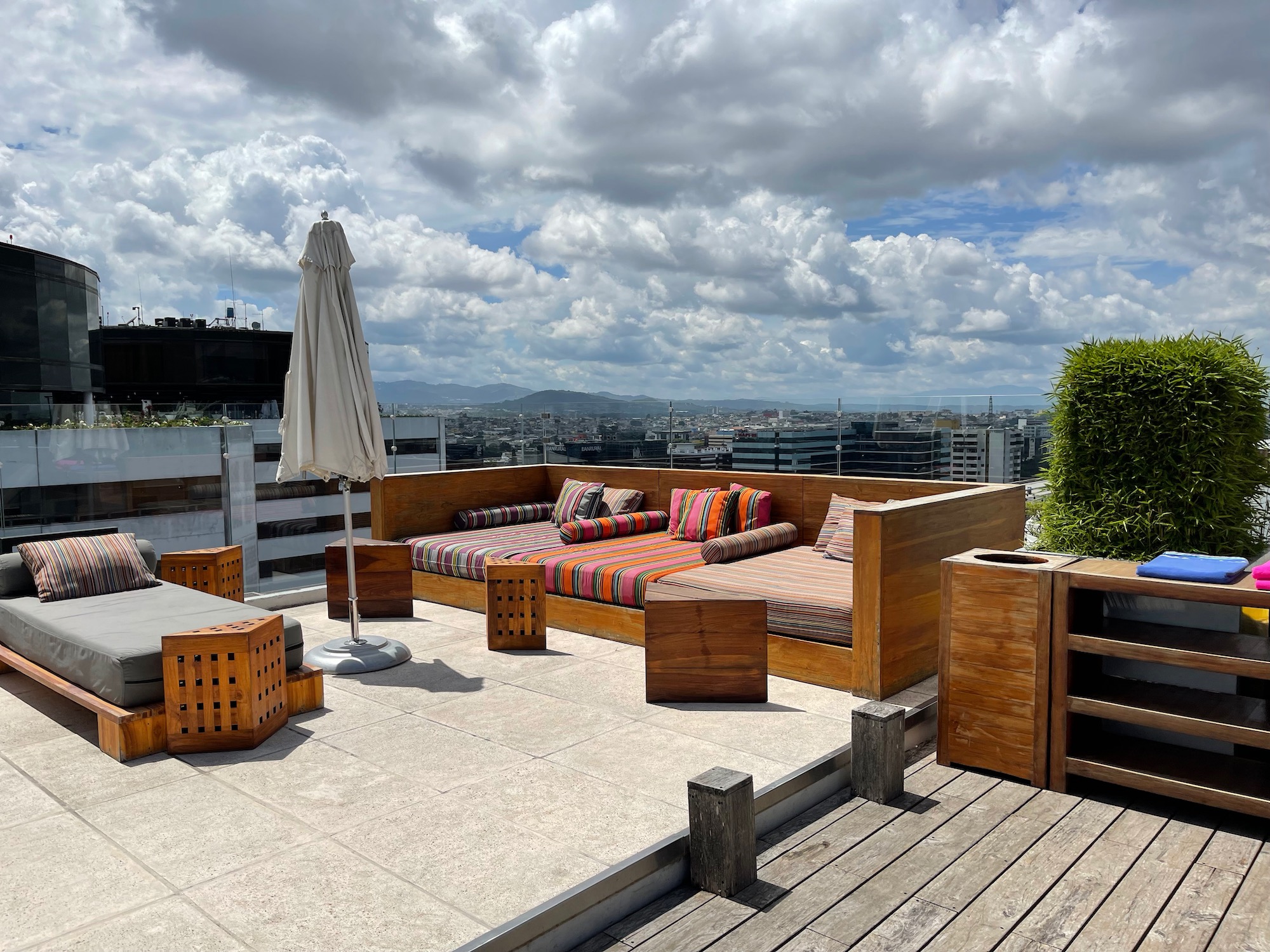 a patio with a large couch and umbrella on a rooftop