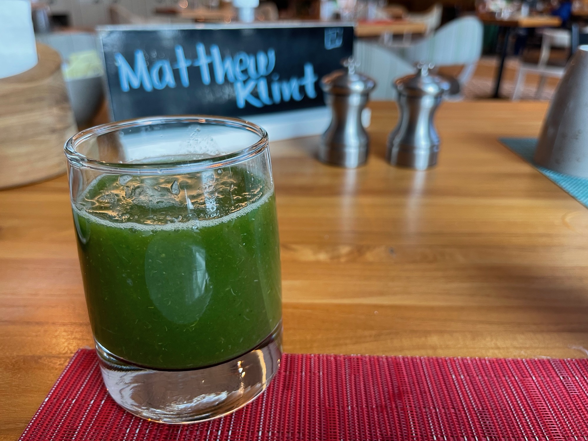 a glass of green liquid on a table