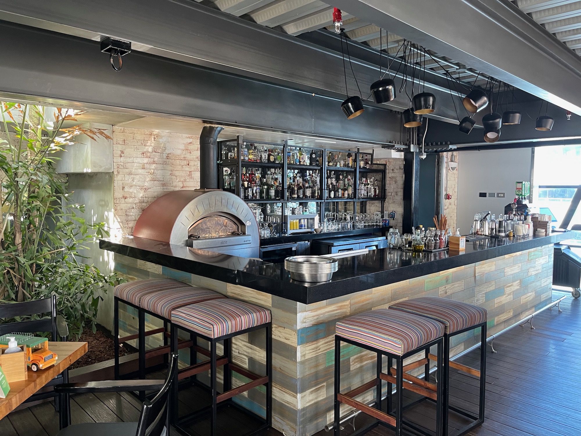 a bar with stools and a pizza oven