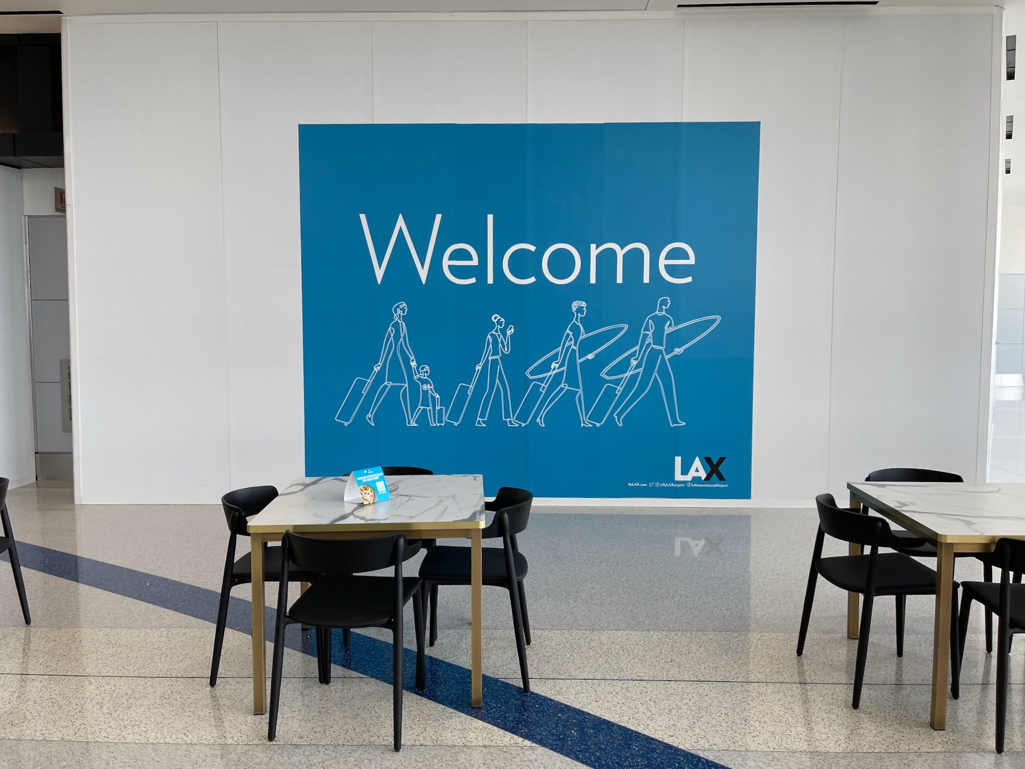 a table and chairs in a room with a welcome sign