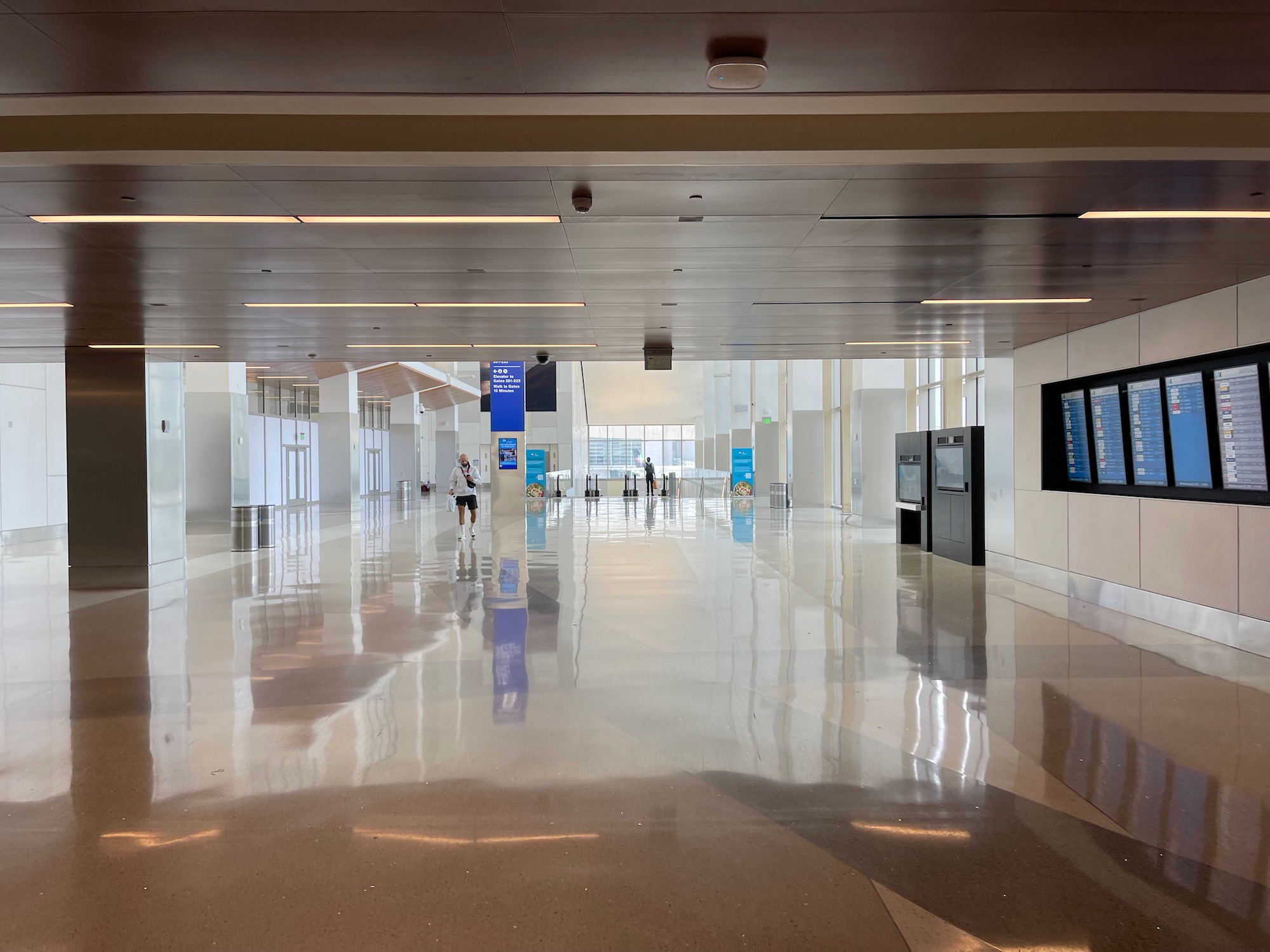 a large white hall with people walking in it