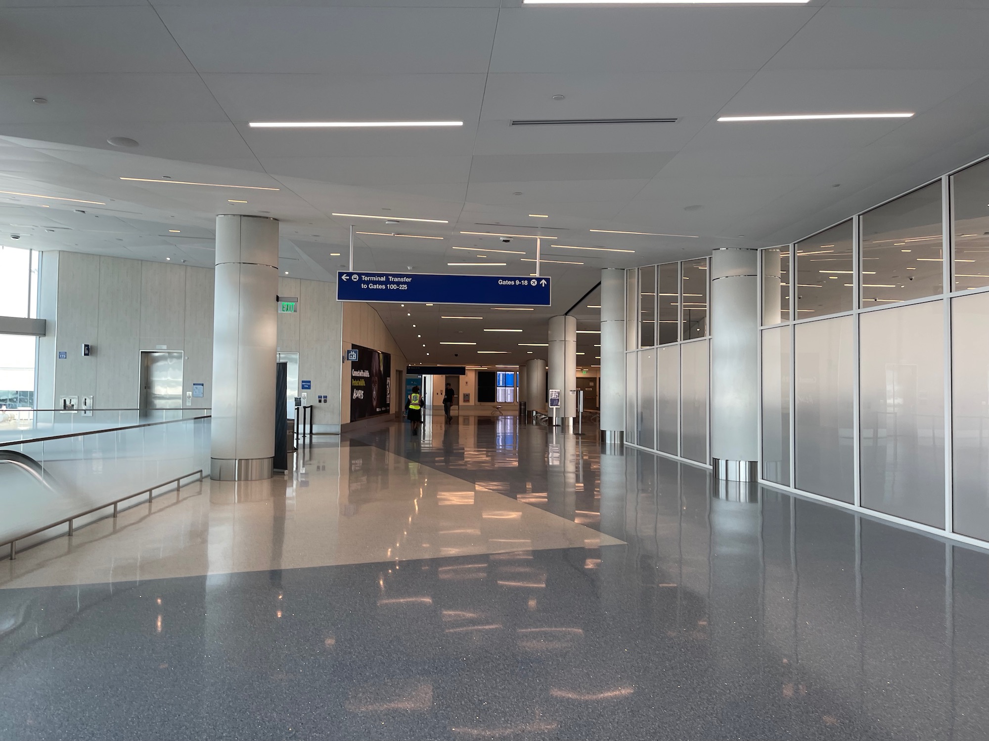 a large hallway with a blue sign and a man walking