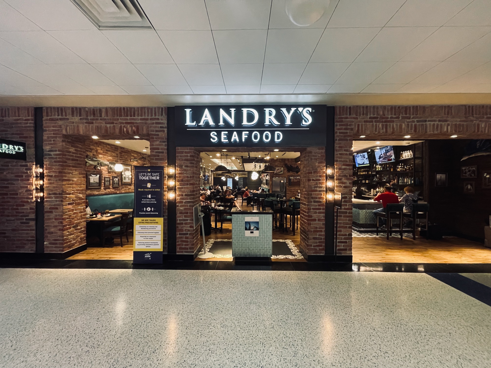 a restaurant entrance with brick walls and lights