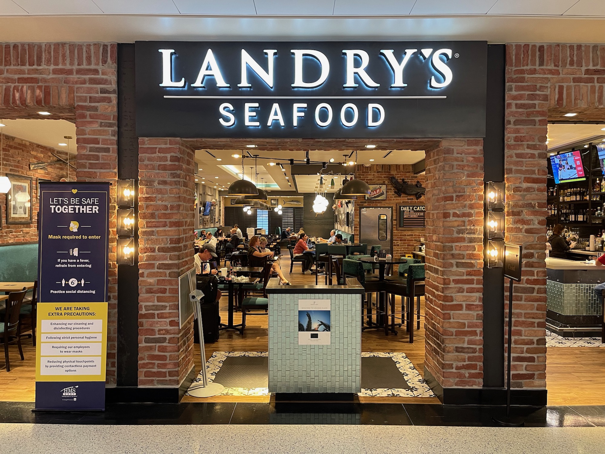 a restaurant entrance with brick archways and people inside