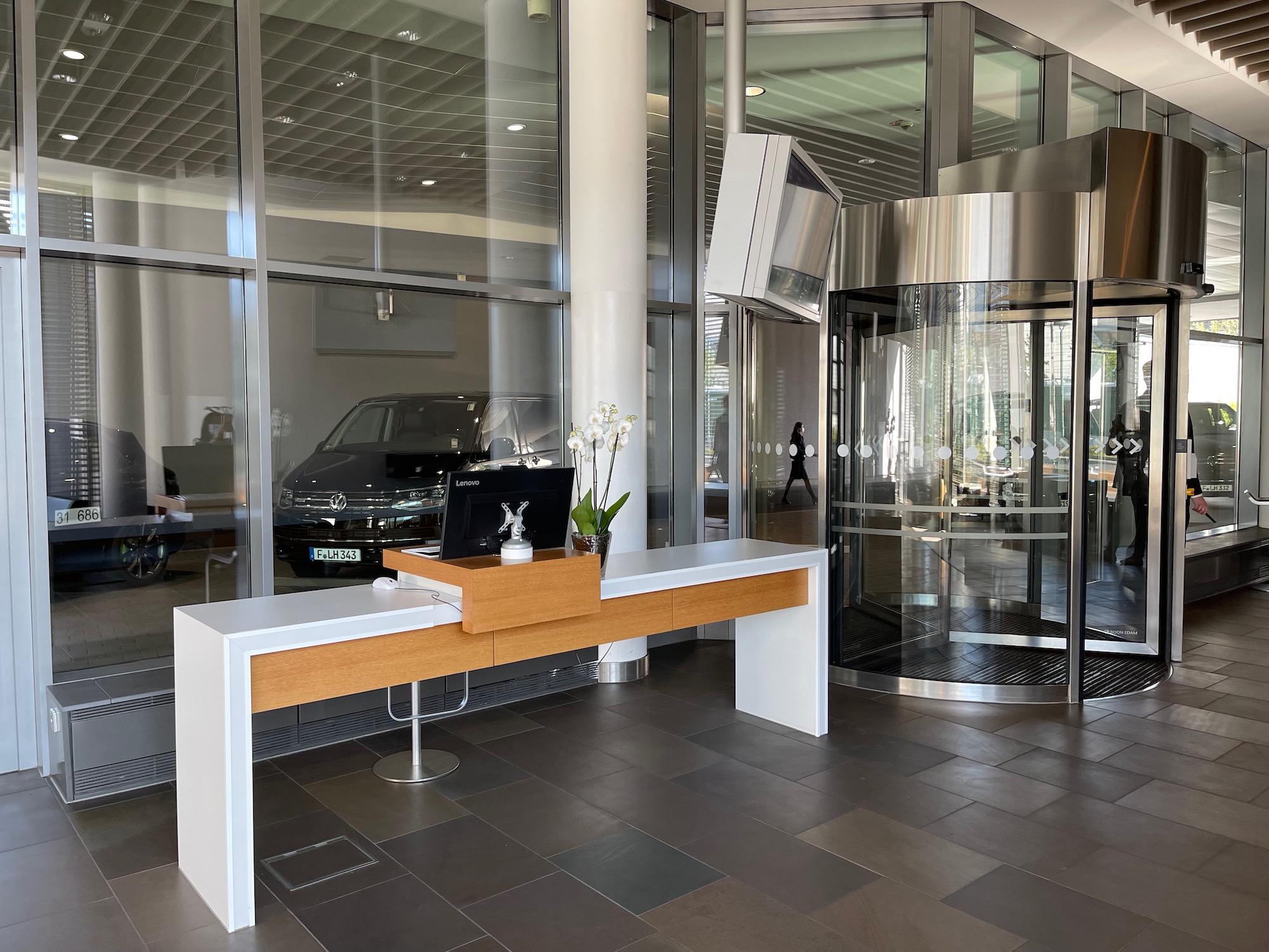 a glass elevator with a desk and a laptop on it