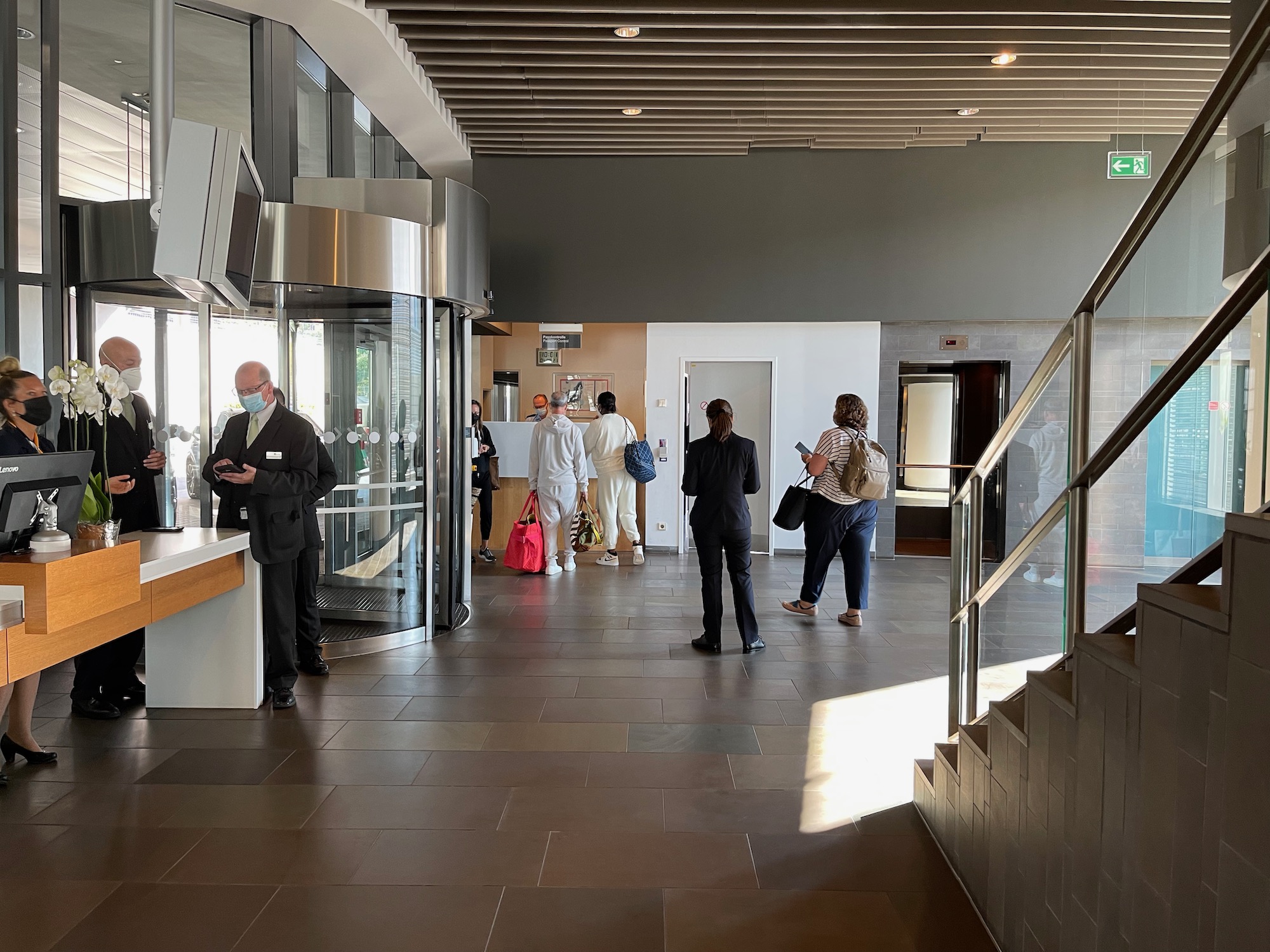 people in a building with people walking in front of a glass door