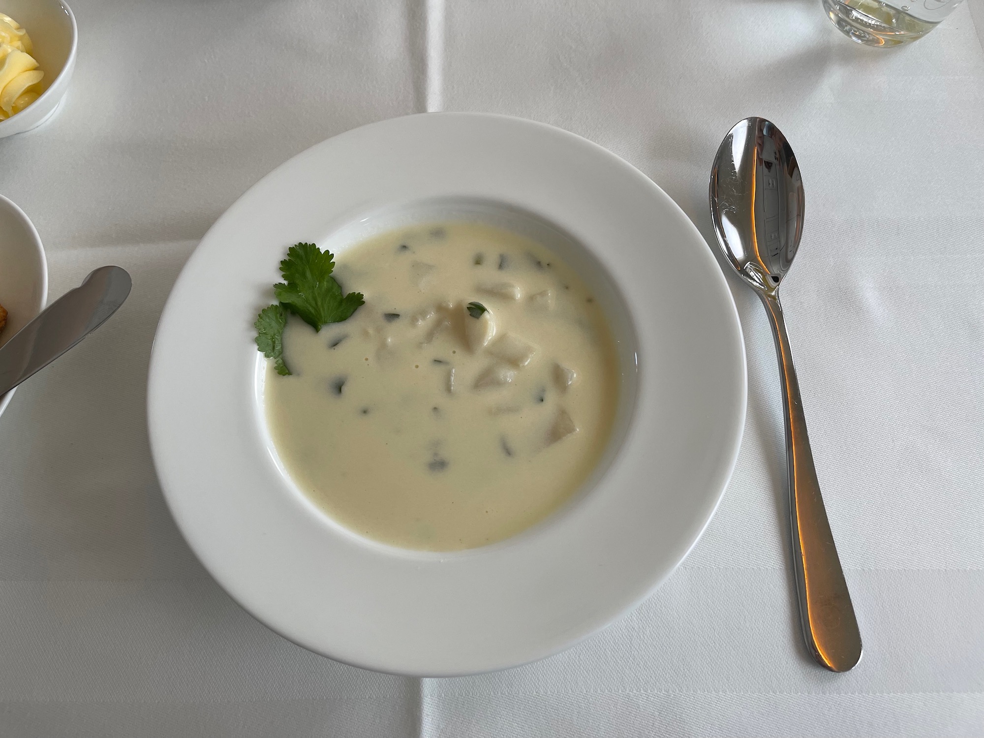 a bowl of soup with a spoon and a fork