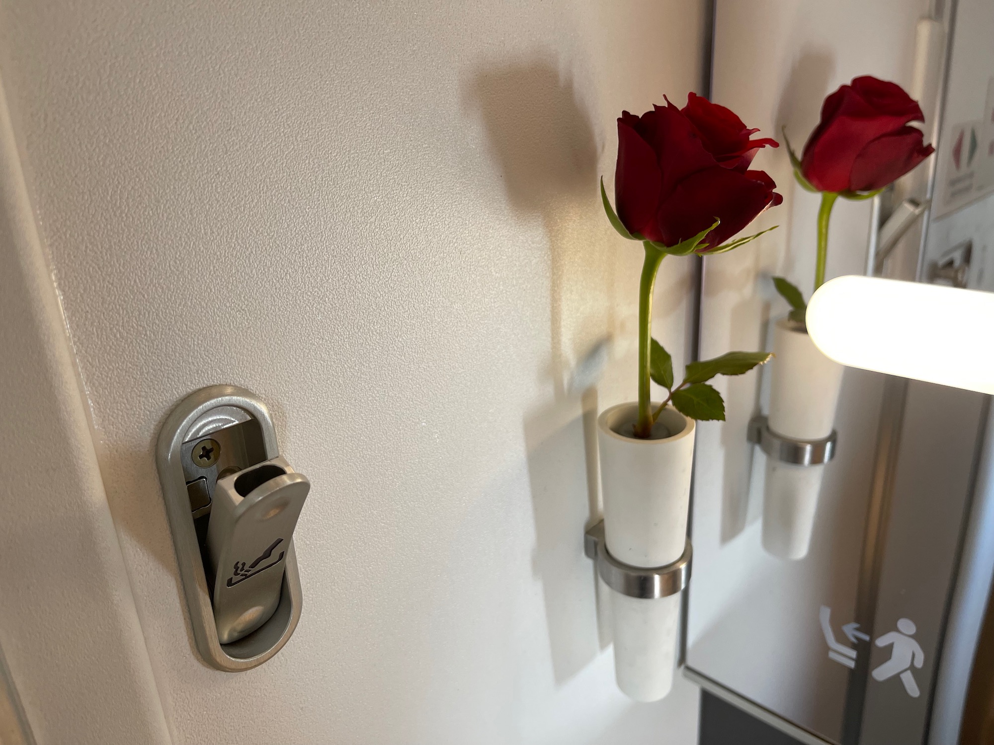 a red roses in vases on a wall