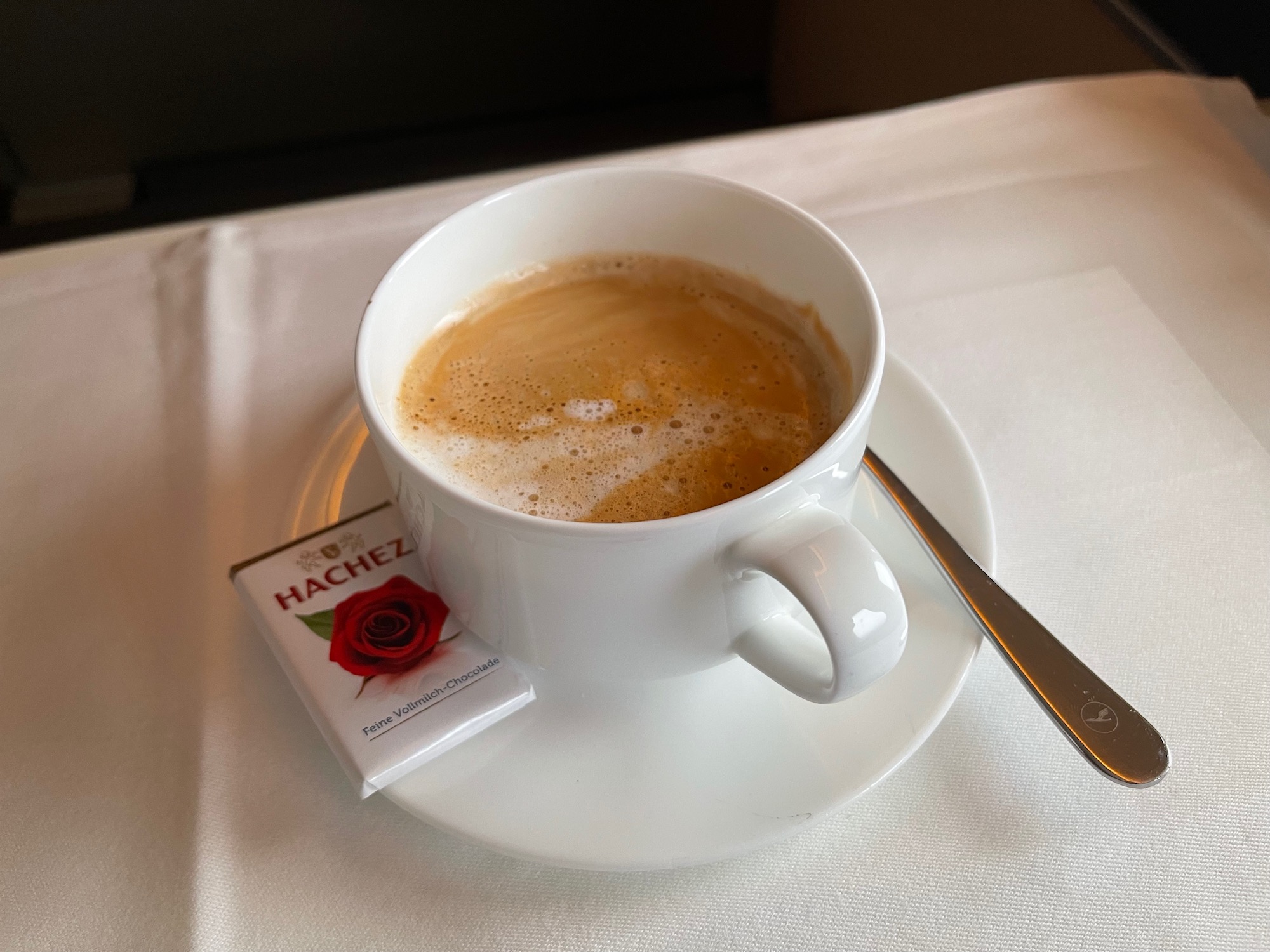 a cup of coffee on a saucer with a spoon