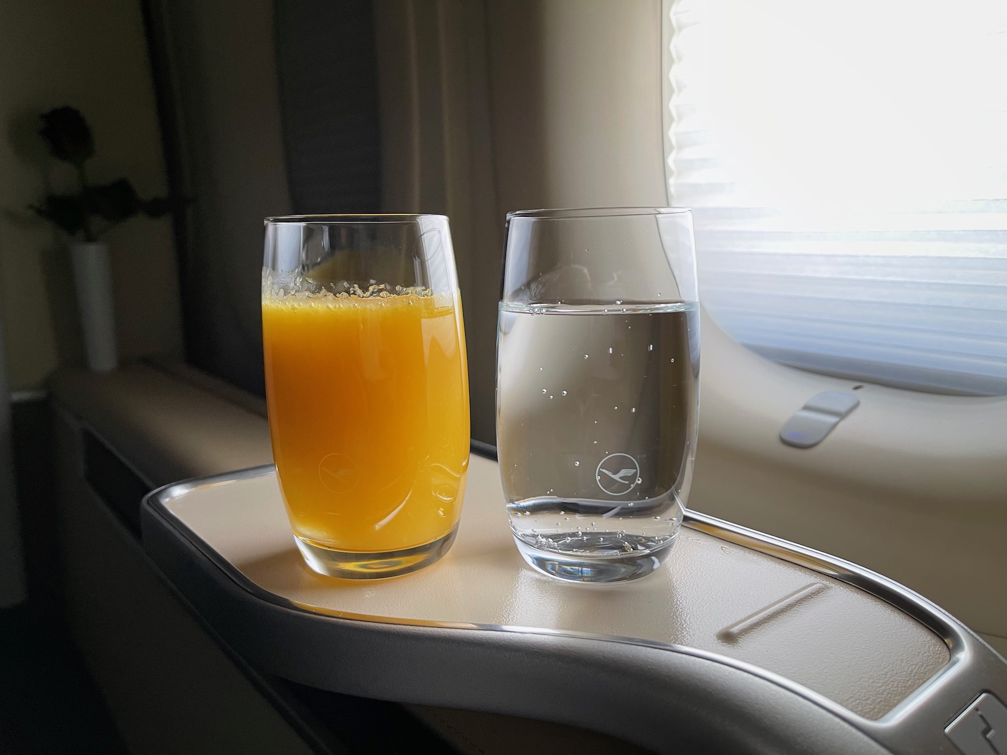 a glass of water and a glass of orange juice on a tray