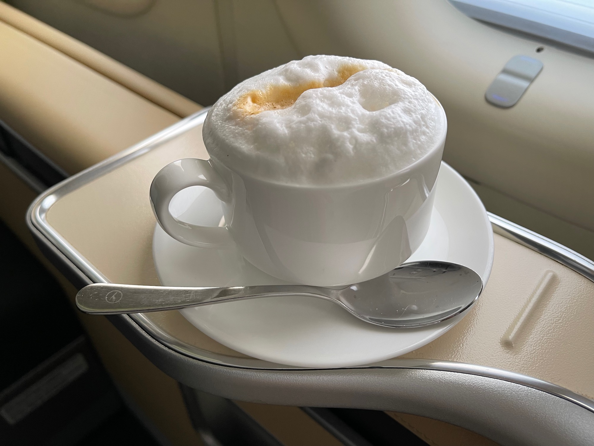 a cup of coffee on a saucer with a spoon