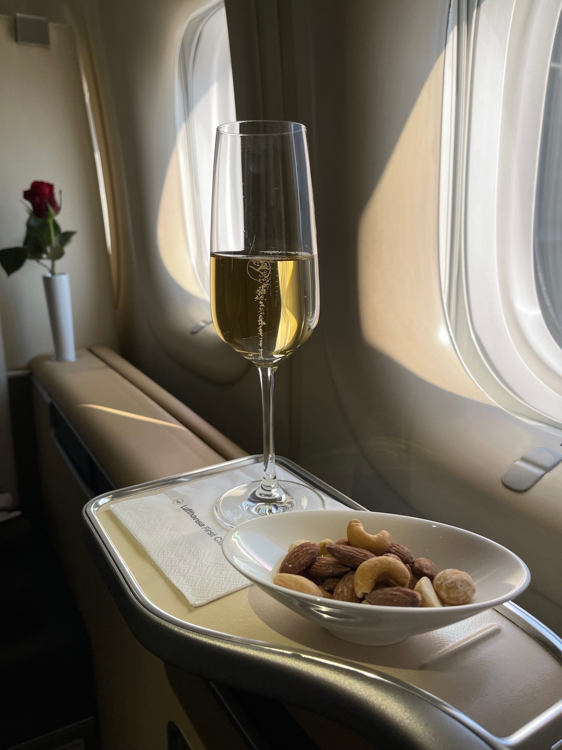a glass of champagne and a bowl of nuts on a table
