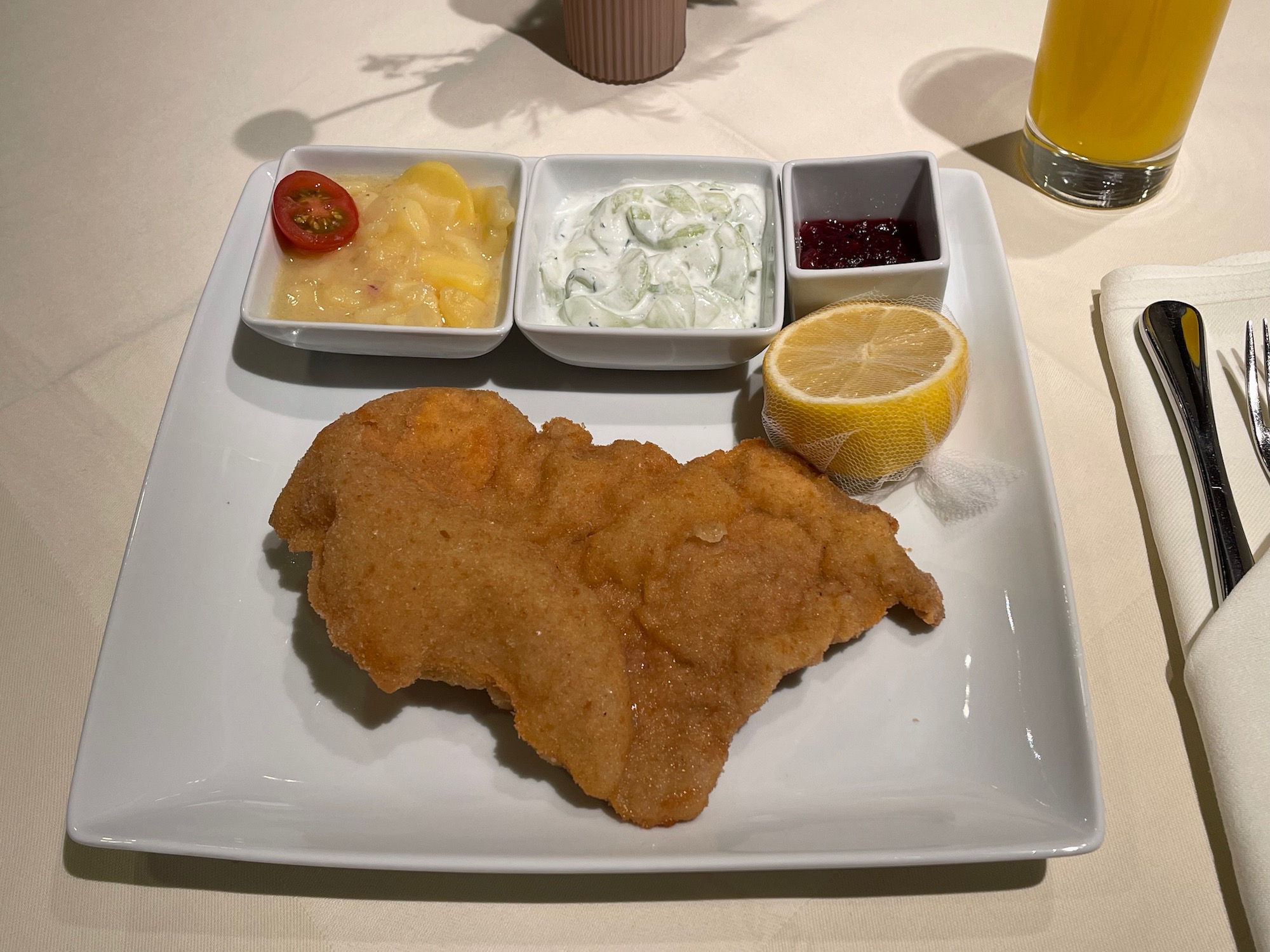 a plate of food with a lemon wedge and sauce