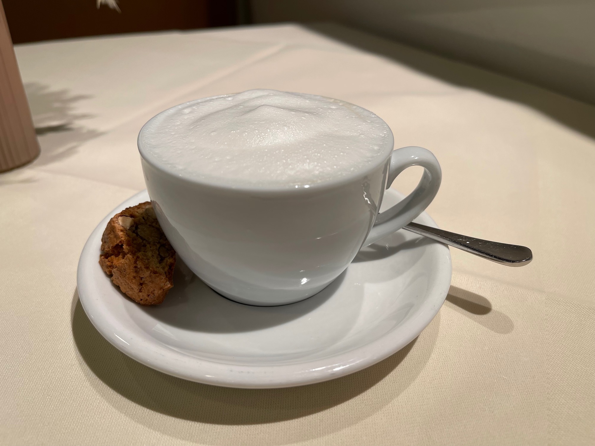a cup of coffee and a cookie on a saucer