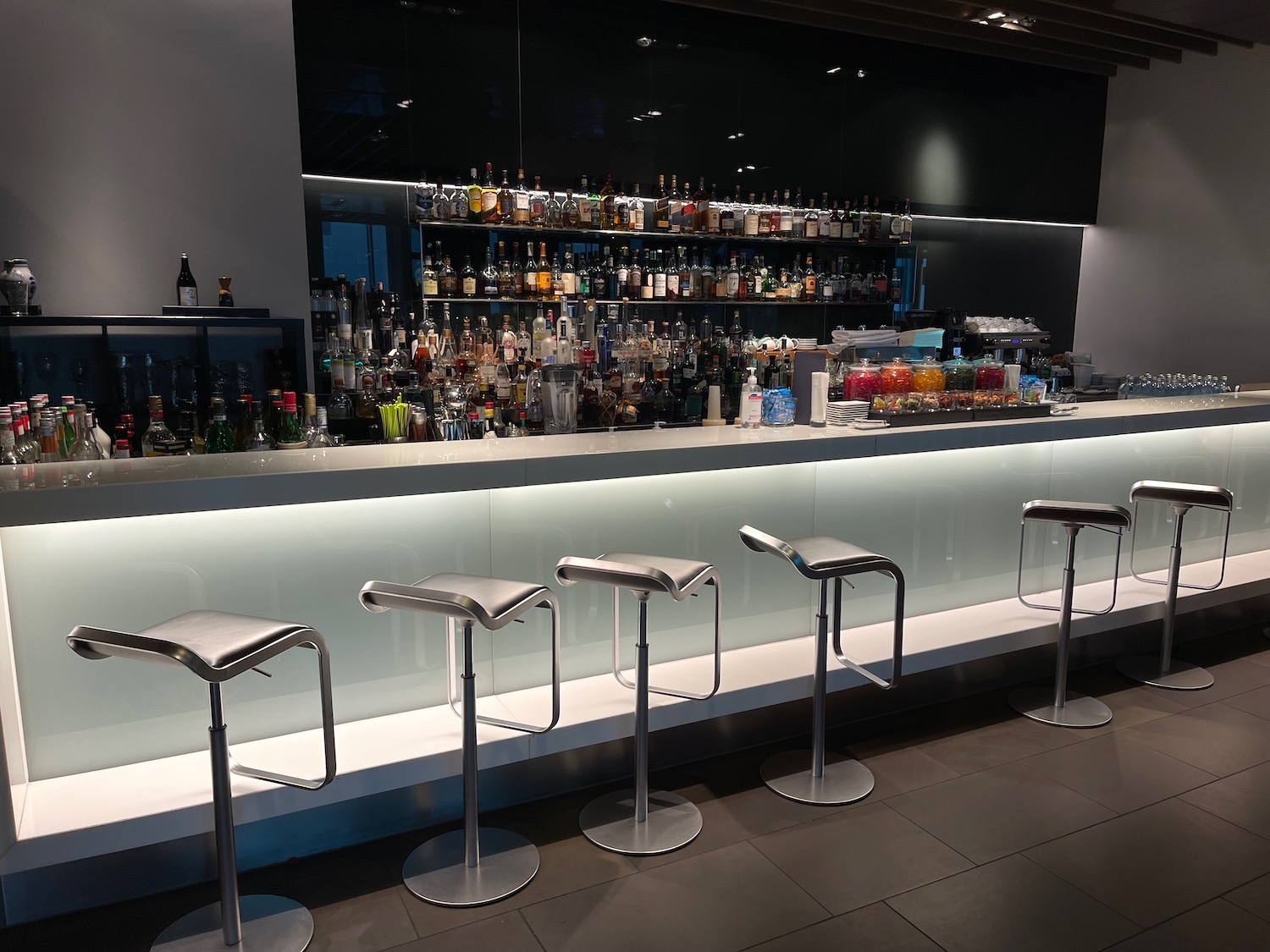 a bar with many stools and bottles